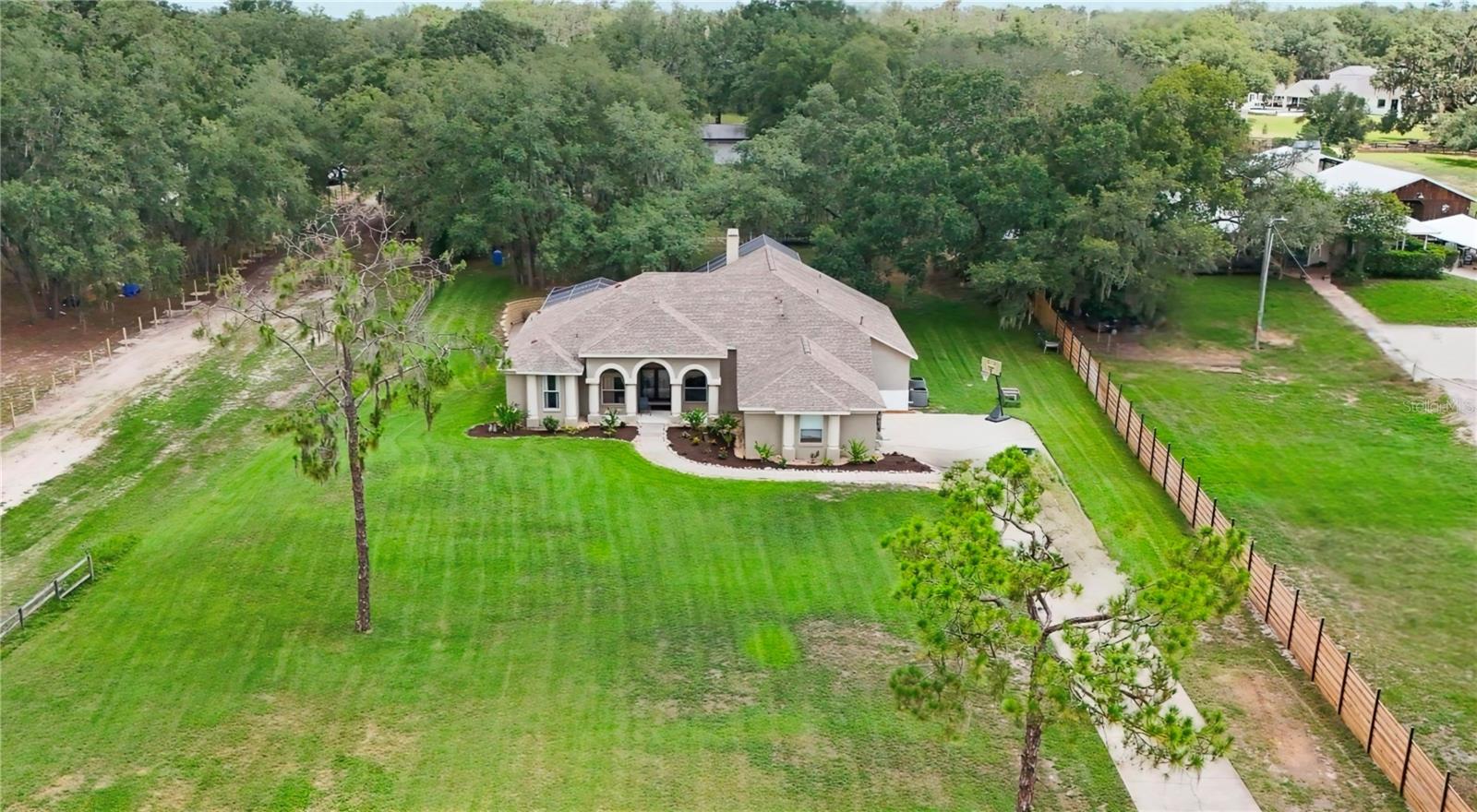 Welcome to your own slice of paradise on Shadow Run Blvd at 13020 Shadow Run Blvd in Riverview, Fl 33569. A rare ASC1 zoned 2-acre retreat directly across from the scenic 178-acre Grady Lake in the heart of Riverview, FL. This sprawling 3,117 sq ft estate offers 5 spacious bedrooms and 4 full bathrooms, giving your family room to grow, gather, and entertain for years to come. Step inside to find rich wood flooring flowing through the formal living and dining rooms, framed by elegant crown molding that sets a warm, upscale tone from the moment you walk in. Two cozy fireplaces make this home perfect for holiday gatherings and quiet Florida evenings alike. The open-concept kitchen is a true showstopper, featuring cherry cabinetry, rich granite wrapped countertops, complete with a double refrigerator package, and a deep chefs custom sink that overlooks the sunlit family living area, ideal for hosting while staying part of the conversation. Outside, the possibilities are endless. With 2 full acres, there's ample room for RVs, boats, trailers, and all your toys, plus a large storage shed in the back, it’s perfect for a home-based business, workshop, or extra equipment storage. Unwind in the screened-in lanai overlooking your private pool and spa, or fire up the outdoor kitchen for al fresco dining under the lights well into the evening. A long private driveway leads to an oversized 3-car garage, offering plenty of parking and storage for the whole family. Located minutes from shopping, dining, top-rated Hillsborough County schools, and easy access to I-75 and the Tampa Bay area, 13020 Shadow Run Blvd offers the rare combination of privacy, space, and convenience. Homes like this with acreage, lake frontage views, and this level of indoor-outdoor living, don't come around often in Riverview. Schedule your private showing today before this one-of-a-kind estate is gone!