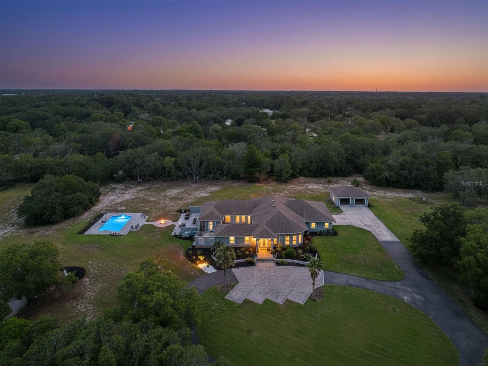INCREDIBLE 9.8 ACRE ESTATE PROPERTY right in the heart of Spring Hill - rare to find!! 3,676 sq ft living space; 6,327 total sq feet!!! Sprawling estate offers 3 bedrooms + BONUS ROOM off the master bedroom + 3 full bathrooms + PRIVATE OASIS POOL (heated and saltwater with paver deck) + 2-car attached garage + 2 car detached garage + air-conditioned workshop inside + brick paver outside fire-pit + paved winding driveway up to the home with extra parking + 2 RV Hookup sites + NO HOA (bring your boat, RV, ATVs, bring it all) + NO FLOOD + Privacy you only dream of having this close to town + partially fenced + irrigation system + large living room + large family room + formal dining room + breakfast nook + large walk-in pantry + extra large laundry room + incredible outdoor living space including a large covered lanai + large party lanai for entertaining your family and friends! Plus all of this is nestled on 9.8 acres of private land!! This is a must see, gorgeous estate home!! GRAND and IMPRESSIVE home from the minute you drive up and walk inside the large, tall double glass entry doors and your see the impressive high, architectural ceilings, designer glass windows, and transom windows!! All of this along with the open floor plan makes this home feel very spacious, light, bright, and cheery! You can't help but admire the incredible details in the home! This is not your average home! Your family and guests will be impressed every time they walk in!!

The impressive, upgraded kitchen is the show-stopper of this home!! It offers upgraded, real wood, kitchen cabinets with glass cabinets above, stainless steel range-hood, stainless steel farm sink, gas stovetop, built-in oven and microwave, designer faucet, granite counter tops and large granite breakfast bar for extra seating!! Just look at the ceiling int he kitchen!! There is a large coffee bar with extra cabinets and glass cabinets above - great for serving food during parties or making your morning coffee...or evening nightcap!  The pantry is large enough to be a bedroom in itself!! You have so much storage for all your food items and small kitchen appliances!! The kitchen is open to the large family room!!

The outdoor living space is stunning...so much space for entertaining! You could host a wedding out here...it's so beautiful!! Large patio offering privacy and a large pool deck in this oasis-style pool! It's heated for the winter months so you can use it year round!! 

One of the bedrooms is its own ensuite for the ultimate privacy for guests or in-laws! Every room has its own bathroom...but the master ensuite bathroom is larger than the huge master bedroom!!  The master suite also offers TWO large walk-in closets and its own bonus room that you can use for your private home gym or office!! So much space just in the master suite!!

The attached 2-car garage also has a 16x14 workshop inside that is air-conditioned!! Use as a man-cave or workshop...it's such a great space to have!!  The ADDITIONAL detached garage is 22x22!!

Close to everything!! Shoppes, restaurants, hospitals, schools!! Less than 10 minutes to kayaking, paddle-boarding, and swimming with the manatees in the clear Weeki Wachee River or enjoying a day at Buccaneer Bay Water Park!! Sunsets at Pine Island, boating and fishing!! Less than 10 minutes to the Suncoast Parkway for quick & easy access to Tampa International Airport!! 1 hour + to TOP US BEACHES!! 

A MUST SEE!! DON'T MISS IT!!