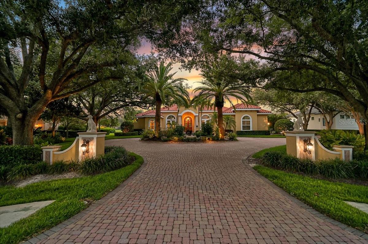 **EXPERIENCE TIMELESS ELEGANCE AND EXCEPTIONAL CRAFTSMANSHIP** in this impeccably maintained Arthur Rutenberg custom residence, perfectly positioned on a private 0.61-acre homesite overlooking the Heron Golf Course with tranquil water views in the prestigious, 24-hour gated Oaks Club community. Nestled beneath a gorgeous oak canopy and enhanced by professional exterior landscape lighting, this remarkable 4,012-square-foot home offers the utmost in Florida living.
Designed to maximize natural light, soaring 12-foot ceilings, expansive windows, and seamless indoor-outdoor living, the home was affectionately known by its previous owners as "The House of Light." From the dramatic circular driveway and lighted entrance columns to the elegant coffered ceilings, crown molding, and inviting gas fireplace, every detail reflects the quality and sophistication synonymous with Arthur Rutenberg.
The thoughtfully designed floor plan features 4 Bedrooms plus Private Study/Den, 3 Full and 1 Falf Baths, centered around a spacious gourmet kitchen with new granite countertops, premium Sub-Zero and Wolf stainless steel appliances, and an open flow into the comfortable family room—ideal for both everyday living and entertaining.
The luxurious primary suite offers a spa-inspired bath with dual vanities, a custom tiled walk-in shower, and a relaxing soaking tub. An oversized three-car garage provides abundant storage, a workbench, and an additional refrigerator.
The expansive screened lanai is the true centerpiece of the home, offering the ultimate Florida lifestyle with generous covered entertaining space, multiple dining areas, and a stunning pool highlighted by a dramatic four-foot tiled waterfall feature. A fully equipped outdoor kitchen includes granite countertops, an Alfresco grill, refrigerator, and bar seating, creating the perfect setting for year-round entertaining.
Meticulously updated throughout the years, significant improvements include hurricane-impact windows and doors (2020), roof (2019), pool cage/aluminum structure (2018), and numerous additional enhancements that preserve the home's exceptional quality and value.
The Oaks Club is a member-owned private golf community with more than 40 years of excellence and is the only private residential golf club in the Sarasota, Bradenton, and Fort Myers region recognized by both Platinum Clubs of America and Distinguished Emerald Clubs of the World. Residents enjoy a magnificent 30,000-square-foot clubhouse, three exceptional dining venues, two championship 18-hole golf courses, outstanding golf instruction, a premier racquet program with 12 Har-Tru HydroGrid tennis courts and pickleball courts, croquet, bocce, basketball, a Junior Olympic swimming pool, and a newly expanded state-of-the-art wellness, fitness, and spa facility. Recognized as "The Healthiest Club" and an Audubon Society-certified community, The Oaks also welcomes families and offers an unmatched lifestyle.
Ideally located in one of Sarasota County's most sought-after communities, this exceptional home is just minutes from world-renowned beaches, top-rated schools, fine dining, shopping, and Sarasota's vibrant arts and cultural attractions, making it a rare opportunity to enjoy luxury living in a truly prime location.  **Enjoy Viewing the 3D Virtual Tour and Aerial Video*