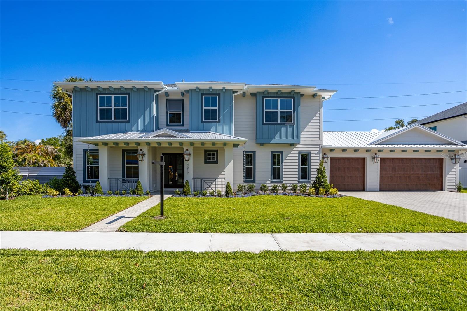 Stunning new construction by MOMENTUM HOMES in the heart of sought-after Virginia Park! This exceptional 4-bedroom, 4.5-bath residence offers 4,253 SF of thoughtfully designed living space with designer-selected finishes throughout. The gourmet kitchen features a full Thermador appliance suite including a 48" gas cooktop, 48" panel-ready refrigerator, and 30" wall oven, complemented by Wellborn cabinetry with 42" uppers to the ceiling, quartz countertops, a spacious island, and under-cabinet LED lighting. Hardwood floors flow throughout the main living areas, while 10-foot ceilings and faux wood beams create a grand yet inviting atmosphere. The primary suite boasts a spa-inspired bath with dual shower heads, freestanding tub with floor-mount faucet, and floating vanity. Additional highlights include a private study with wood beams, dedicated media room, walk-in pantry, mudroom, and custom closets throughout. Step outside to your private oasis featuring a heated pool and spa with mini pebble finish, natural stone deck, and a fully equipped outdoor kitchen with Summerset grill and granite counters. The 3-car garage includes epoxy floors and EV charger pre-wire. Impact windows and doors throughout, two-zone 16 SEER HVAC, natural gas vented fireplace, generator pre-wire, landscape lighting, and smart-home wiring complete this extraordinary home. Welcome home to 4017 W Palmira!