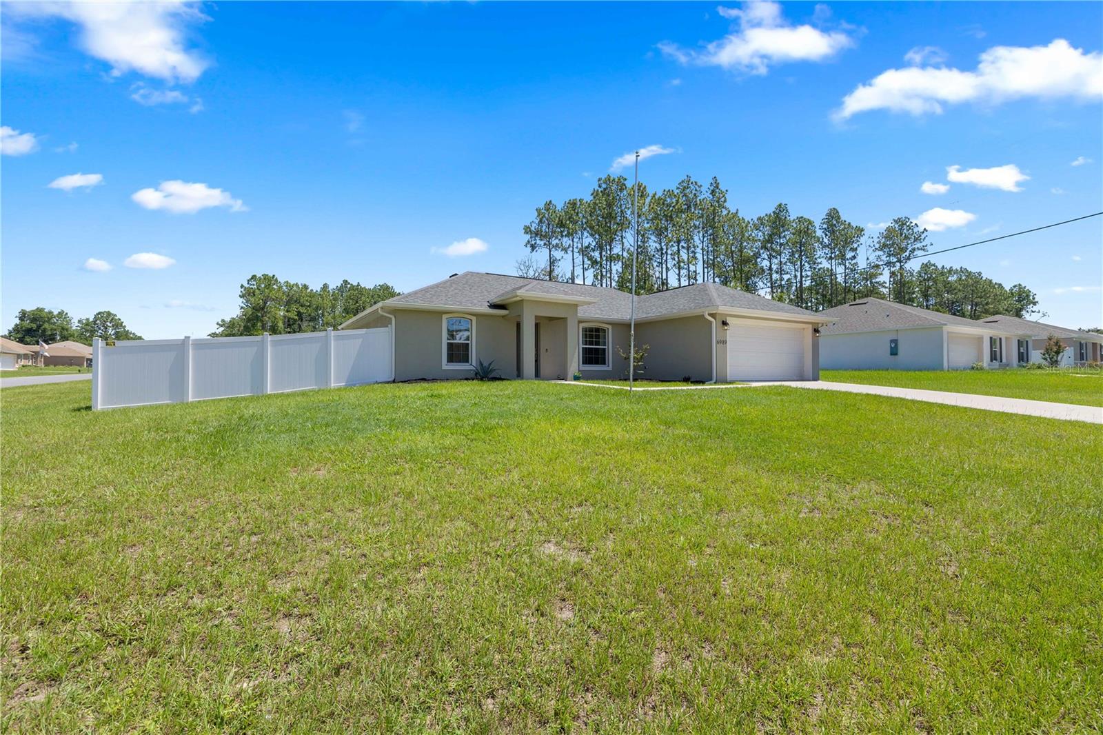 This Bridget II model is a 3-bed, 2-bath, 2-car garage home situated on a Corner Lot with Vinyl Fencing. Check out the LINK for an Interactive Virtual Tour of this beautiful home, built in 2023! Step inside this elegant open floor plan home, featuring vaulted ceilings in the living room, kitchen, and dining area, which creates an open and spacious atmosphere for both living and entertaining. The kitchen boasts stunning soft-close wood cabinetry, stainless steel appliances, and luxurious granite countertops. The eight-foot granite breakfast bar is perfect for entertaining, as it overlooks the living room. The kitchen flows into the dining area, which is equipped with French doors that lead to the screened back lanai. Enjoy entertaining guests on the screened, covered lanai, which opens up to a paver patio ideal for grilling or sunbathing. All bedrooms and the living room are fitted with ceiling fans, and the upgraded split unit HVAC system ensures that temperatures can be customized in each living area, providing efficient and economical cooling. The master bedroom includes a walk-in closet and a custom tile master bath, featuring a soft-close wood vanity and granite countertop. This block construction home comes with upgraded plumbing and lighting fixtures throughout. The new elementary school is finished, and a new high school is set to open in August 2026. The location is convenient to shopping, medical facilities, Interstate 75 to Orlando, restaurants, and more. Marion Oaks amenities include a community center with a library, auditorium, and recreational facilities such as a splash pad, fitness center, and sports courts for basketball, tennis, pickleball, and volleyball. Outdoor amenities feature parks, playgrounds, and walking/biking trails, while the community offers easy access to shopping and dining, along with nature areas like the Cross Florida Greenway and the Dunnellon Rainbow River. Schedule your tour today!