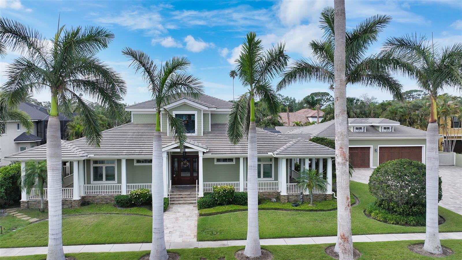 West of Trail! Custom Build by Voight Construction. Nestled in one of Sarasota’s most coveted neighborhoods, this exceptional custom estate spans over three expansive lots and boasts craftsmanship that is truly one-of-a-kind. A celebration of fine design, this home features intricate millwork, rich stained oak floors, and soaring ceilings adorned with stunning pecky cypress inlays.

Step inside to discover a warm and inviting chef’s kitchen with handcrafted cabinetry, luxurious stone countertops, and character-filled details throughout. The open floor plan flows effortlessly into elegant living and dining spaces, all surrounded by oversized windows and French doors that invite the outdoors in.

Enjoy the Florida lifestyle year-round on the charming wraparound porch, by the private pool, or grilling in the fully equipped outdoor kitchen. A spacious guest house provides the perfect retreat for visitors, while the rare 6-car garage is a dream for car enthusiasts or collectors.

Located west of the trail, just minutes from downtown Sarasota, this estate offers unmatched privacy, artistry, and convenience — a true architectural gem rarely found in today’s market.