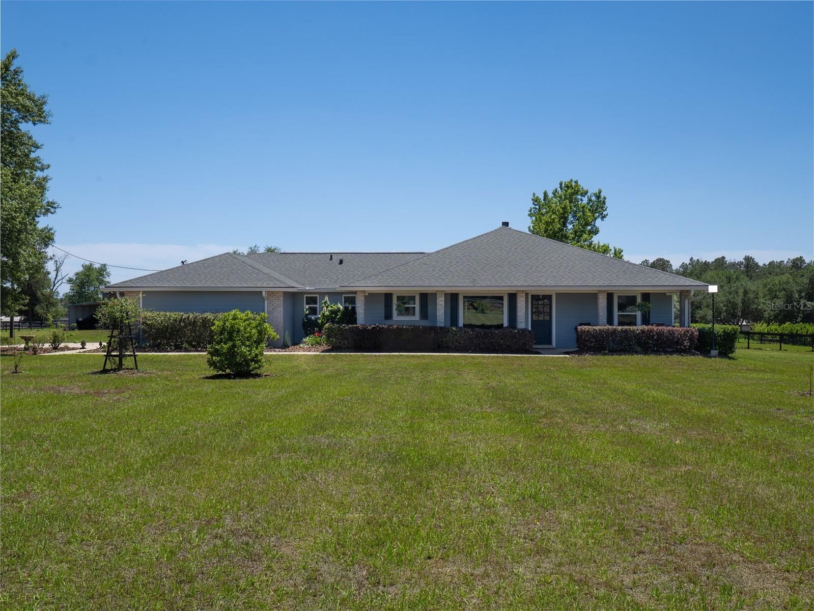This beautifully updated 5-bedroom, 3-bath concrete block home with a newly constructed private pool is set on 5 high and dry, fully fenced acres on a corner lot, offering a rare combination of space, flexibility, and modern efficiency just minutes from Gainesville. Designed with versatility in mind, the home features a split floor plan, two spacious living areas, and dual primary suites, creating an ideal layout for a variety of living arrangements, extended stays, or flexible use of space—all while maintaining privacy and comfort. A major highlight of the property is the newly constructed saltwater pool and travertine lanai, creating a true outdoor retreat perfect for both relaxing and entertaining. The fully fenced acreage, enhanced with privacy hedging and automatic gated entry, provides a peaceful setting with room to enjoy the outdoors without sacrificing convenience. Inside, the home has been thoughtfully renovated with both style and efficiency in mind. Updates include new flooring (2025), a remodeled kitchen, updated lighting and fixtures, new HVAC (2025), two new water heaters (2025), and energy-efficient windows with a transferable warranty. Combined with Clay Electric utilities, these improvements help provide a more energy-conscious living experience—addressing one of the biggest concerns buyers have with larger homes. The property also includes a newly constructed barn, offering flexibility for hobbies, storage, workspace, or animals, while still maintaining a clean, approachable feel for a wide range of buyers. Enjoy the feeling of privacy and quiet living while remaining just a short drive to Gainesville’s shopping, dining, medical facilities, and everyday conveniences. This is a rare opportunity to own a move-in ready pool home on usable acreage, where thoughtful upgrades, flexible living space, and a peaceful setting come together seamlessly.