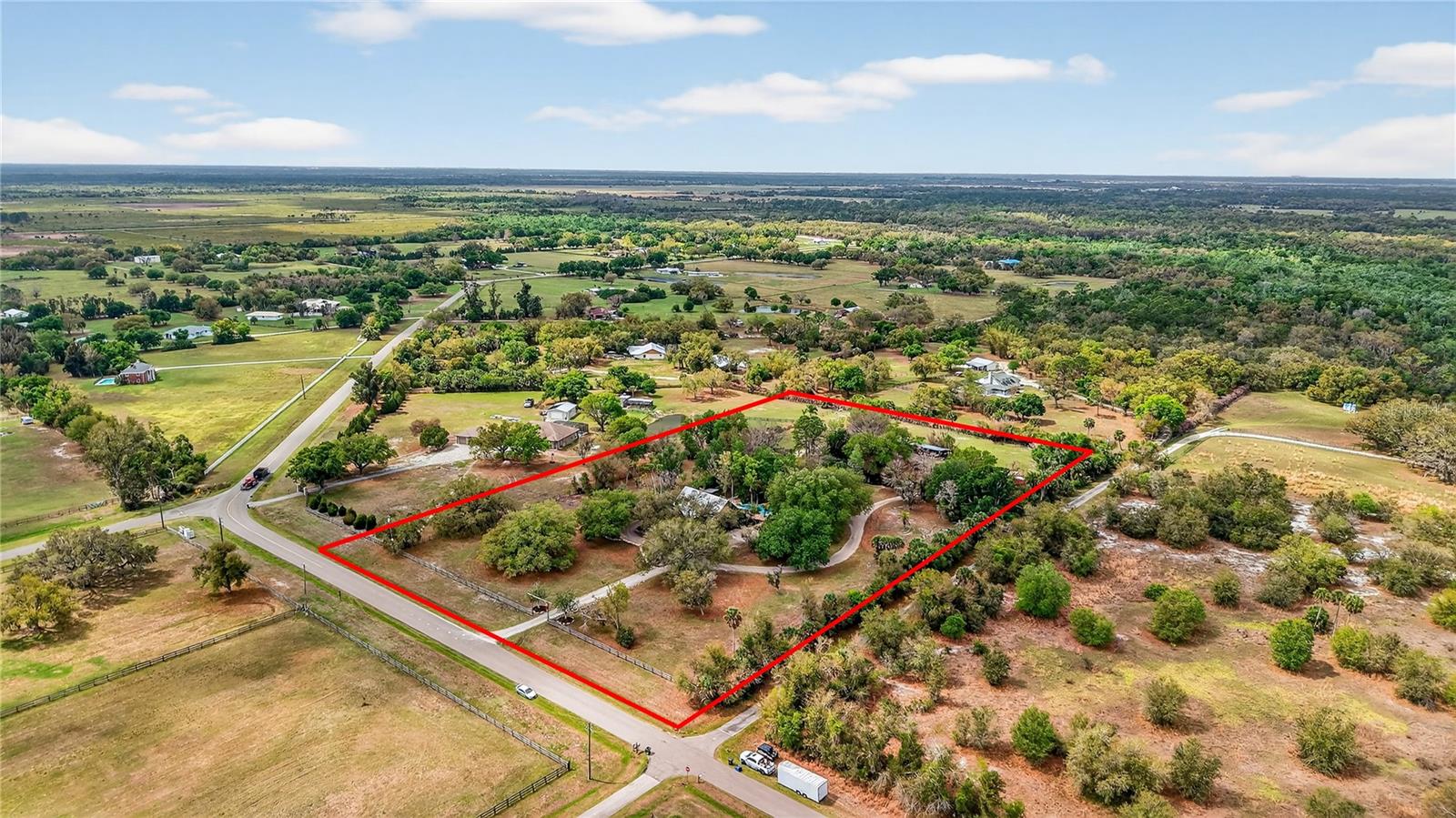 Looking for a Sarasota property where you can have horses, a guest cottage, a pool oasis, and 6 acres of privacy just 30 minutes from Siesta Key Beach?

This private Sarasota acreage estate offers the perfect blend of country living, outdoor entertaining, and equestrian potential while still remaining convenient to Sarasota’s amenities and top-rated schools.

Situated on 6 fully fenced acres, this unique property features a 4 bedroom, 2 bathroom custom home built in 1994 and a 1 Bedroom, 1 Bathroom guest cottage, surrounded by majestic oak trees, lush landscaping, and wide-open space to enjoy Florida’s natural beauty. Designed with solid wood construction and rustic country character, the home offers warmth, charm, and architectural details rarely found in newer homes, including high ceilings and a beautiful stained glass accent that add personality and craftsmanship throughout the interior.

Inside, the layout offers flexibility with two bedrooms and two bathrooms downstairs, including the primary suite, and two additional bedrooms located upstairs. The primary bathroom has been recently updated with a mountain-lodge inspired shower featuring rock textures and marble-look walls, adding to the home's rustic character. Recent updates provide peace of mind for future owners, including all water plumbing lines replaced in 2023, a new hot water heater, new garbage disposal, new kitchen appliances, new ceiling fans, newly resurfaced pool (2026) and a recently serviced septic system.
The outdoor living space is truly the highlight of this property. Step onto the back porch overlooking a tropical backyard oasis featuring a lagoon like pool and spa creating the perfect setting for relaxing or entertaining. The pool area is surrounded by extensive landscaping, large decorative rock accents, and even a poolside stage, making this home ideal for gatherings, celebrations, and outdoor entertaining. 

The property also features a private exterior guest cottage / mother-in-law suite with 1 bedroom, 1 bathroom, and a kitchenette, designed with a cozy country theme. This flexible space could serve as an Airbnb rental, guest house, private office, multigenerational living space, or retreat for visiting family and friends.

For those seeking room for hobbies, vehicles, or animals, the property includes a large six-bay shed / barn structure that can be used for horse stalls, farm equipment, workshop space, car storage, or recreational vehicles. The land also features a pond and a separately fenced pasture, offering excellent potential for horses, hobby farming, or simply enjoying the peaceful country setting.
Unlike many properties in the area, this home is located within the Voluntary Section of the HOA, allowing owners the freedom to bring boats, trailers, campers, work trucks, RVs, and recreational equipment onto the property.

Residents of Myakka Valley Ranches enjoy private paved roads, two community nature parks, miles of riding and walking trails, and close proximity to Myakka River State Park, creating a unique outdoor lifestyle while remaining conveniently located approximately 30 minutes from Siesta Key Beach and about 45 minutes from downtown Sarasota.

Properties like this are rare to find — a Myakka Valley Ranches horse property in Sarasota with acreage, guest cottage, pool, and barn, offering privacy and space while still being close to city amenities. Schedule your private showing today!