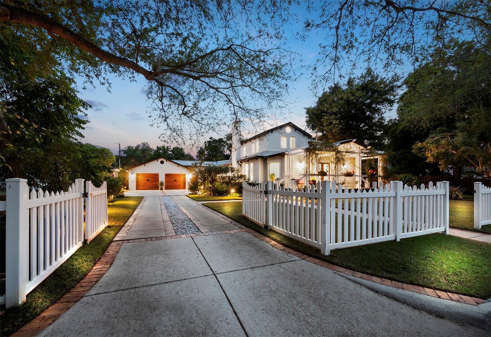 In a coveted West of Trail location within minutes of Southside Village, Sarasota Memorial Hospital, and Downtown Sarasota, this spacious home blends the historic charm of a classic farmhouse with a fully renovated modern interior. Situated on an enormous double lot, the primary house connects to a two-car garage with a separate dwelling unit that has its own exterior access, offering ideal space for an in-law or nanny suite. The home wraps around a courtyard with a pool that is beautifully shaded by established tropical landscaping for a picturesque indoor-outdoor lifestyle. From the deep porch at the front of the home, double entry doors open to a wide and brightly lit foyer that extends to a large dining area with oversized windows welcoming natural light from every side. Just beyond the dining area, a spacious living room with central fireplace leads to the meticulously renovated kitchen and an adjacent wet bar. The kitchen is a chef’s haven with stainless double-door refrigerator, double wall ovens, six-burner gas range, ample Shaker-style cabinets for storage and display, and granite countertops. Past the kitchen, there is an enormous amount of living space that flows from a large breakfast room to a separate lounge and a solarium with vaulted ceiling and wraparound windows overlooking the pool and rear yard. On the opposite side of the home from the kitchen and well-positioned for privacy, the downstairs owners’ suite encompasses an oversized bedroom with a full wall of sliding doors that open to a secluded patio, and a luxurious bathroom with dual vanities, glass-enclosed walk-in shower, and freestanding soaker tub. Outside of the owners’ suite, a spacious vestibule offers dedicated work-from-home space alongside the staircase that leads to the second floor. Upstairs, there are two bedrooms teeming with natural light, each with vaulted ceilings and access to a shared Jack-and-Jill bathroom. Through the breakfast room beyond the kitchen, a fully enclosed breezeway offers enormous storage and utility space leading to the spotless two-car garage and separate apartment entry. A door at the back of the garage opens to the bedroom of the suite, flowing to the kitchenette at rear where there is a separate exterior door to the back yard. Additional French doors in the bedroom open to the pool area. Exceptionally maintained by long-term owners and on the market for the first time in 27 years, this home evokes the beauty of Americana with reclaimed heart pine floors throughout, large bay windows, a standing seam roof, and a trellised front porch. Complementing the historic beauty, the thoughtful renovations, open flow, recessed lighting and oversized windows offer luxurious comforts. The Hudson Bayou neighborhood is highly sought after for its distinguished schools and proximity to Sarasota’s numerous lifestyle amenities, including shopping, dining, and quick access to the hospital and beaches.