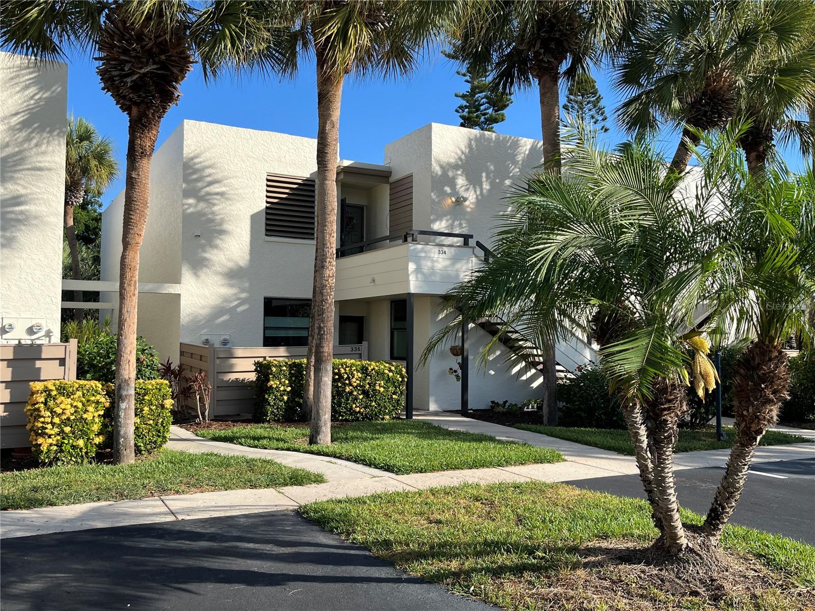 This 1598 square foot condominium home has 2 bedrooms 2 bathrooms. Located in Wildewood Springs Condo Association in a gorgeous natural landscaped 88 acre Audubon and wild life sanctuary featuring lakes, palm trees, live oaks and ban-non trees. Its just a short drive to some of the best Gulf beaches. The exterior is a modernist looking architectural style.The complex was designed by Tim Seibert and is known for it lush tropical  landscape. No age limits and is attractive to active seniors and families. Walking, jogging and biking trails throughout sanctuary grounds. There is storage racks for kayaks near the office as well.
The interior has an open spacial feel with views from the Lanai of pool #3 giving you the feel of your own pool home. There are 7 sparkling pools including a lap pool just a short walk from the front door. It is a quiet first floor end unit with a walkway. The interior is done in neutral colors and it is for the most part turn key if needed (option included).
It has dual pane impact windows in the front bedroom, kitchen and completely across the back Lanai that expose a wide angle view of the outdoors. The front bedroom accommodates queen size or twin beds with ample room for desk and sitting area and dresser. The master bedroom has a California King bed and love seat sitting area and desk as well. Front bathroom is updated with tile and glass. And a modern sink and vanity. The primary master bath has a walk in shower with tile floor to ceiling and glass door. There is a walk-in closet located in the double sink vanity area that is separated from the shower area by a privacy pocket door. The flooring is light grey slate tile and runs throughout the unit. The kitchen has beautiful cherry wood cabinetry including a side coffee bar area with beautiful granite counter tops. All appliances are included and there is a stacked washer dryer located conveniently in a kitchen closet. There are ceiling fans in each bedroom, dinning area and the Lanai. Popcorn ceilings have all been removed and redone. The dining area and livingroom flow into the Lanai and the serene view of the beautiful palms, blue sky, pool and hot tub give you relaxed and peaceful feeling. This is an excellent location for the pool and nature enthusiast just steps away! There is a double door storage area located at the end of the lanai for beach chairs, shelving etc.  HOA  includes basic cable, wifi, water, trash and recycling. Insurance is included and a contingency fund was set up to off set emergency issues that might arise. Also included night time security, On site manager, pool and landscape crew, exterior maintenance, roofs, roadways and the building was just freshly painted. This condo is located just a short walk to tennis and 6 new pickle ball courts as well. Shopping is within walking distance to Publix, Aldi, Detwilers farm market and assorted restaurants, barbers and salons.
