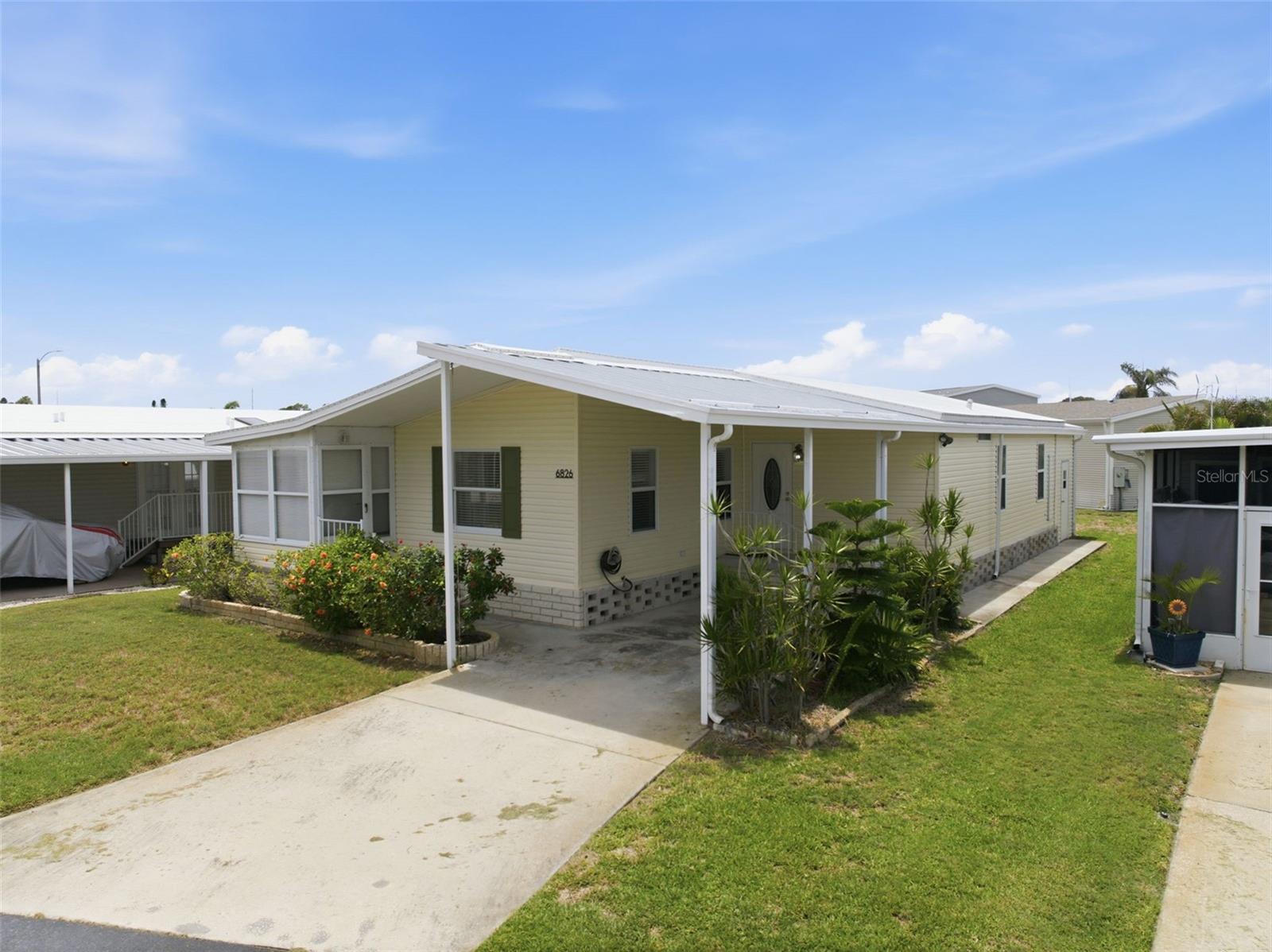 Virtually Staged. This is the ONE you've been waiting for! This 2 bed/2 bath custom-built 1995 home has 1,056 sq ft of living space and is located on one of the most scenic streets in Americana Cove, a 55+ waterfront and gated community only 10 mins to downtown St. Petersburg. Priced to sell, the features are many: 1) 2024 TPO roof reflects heat making home cooler. 2) 2023 HVAC system for efficient heat and air. 3) All new plumbing in 2023. 4) Vaulted ceilings opens up the living space. 5) Separate utility room with washer and dryer makes laundry convenient. 6) Sunny Florida room off living area. 7) Open living/dining/kitchen area makes entertaining effortless. 8) Two spacious bedrooms with primary being ensuite with walk-in shower. Second bedroom would make a great office/den or comfortable bedroom for guests and second bath has tub/shower combo. 9) Outdoors there is a large 2 vehicle carport and spacious storage area for gear, holiday decorations or other storage. 10) No flooding in 2024 storms! Price includes share for the lot and ownership in the Co-op. Pets are welcomed--2 dogs or cats up to 35 pounds each are allowed. Low monthly maintenance fee of $410 includes water/sewer, trash pick up, lawn mowing, 24 hr manned gate, clubhouse, heated pool, fitness center, two boat ramps and so much more! Centrally located to I-275, Tampa, downtown St Petersburg, two airports and minutes from 4th Street shopping, dining, and grocery, you'll enjoy what the area has to offer. Management requires 675 credit score. This is the retirement home that you've been searching for!
