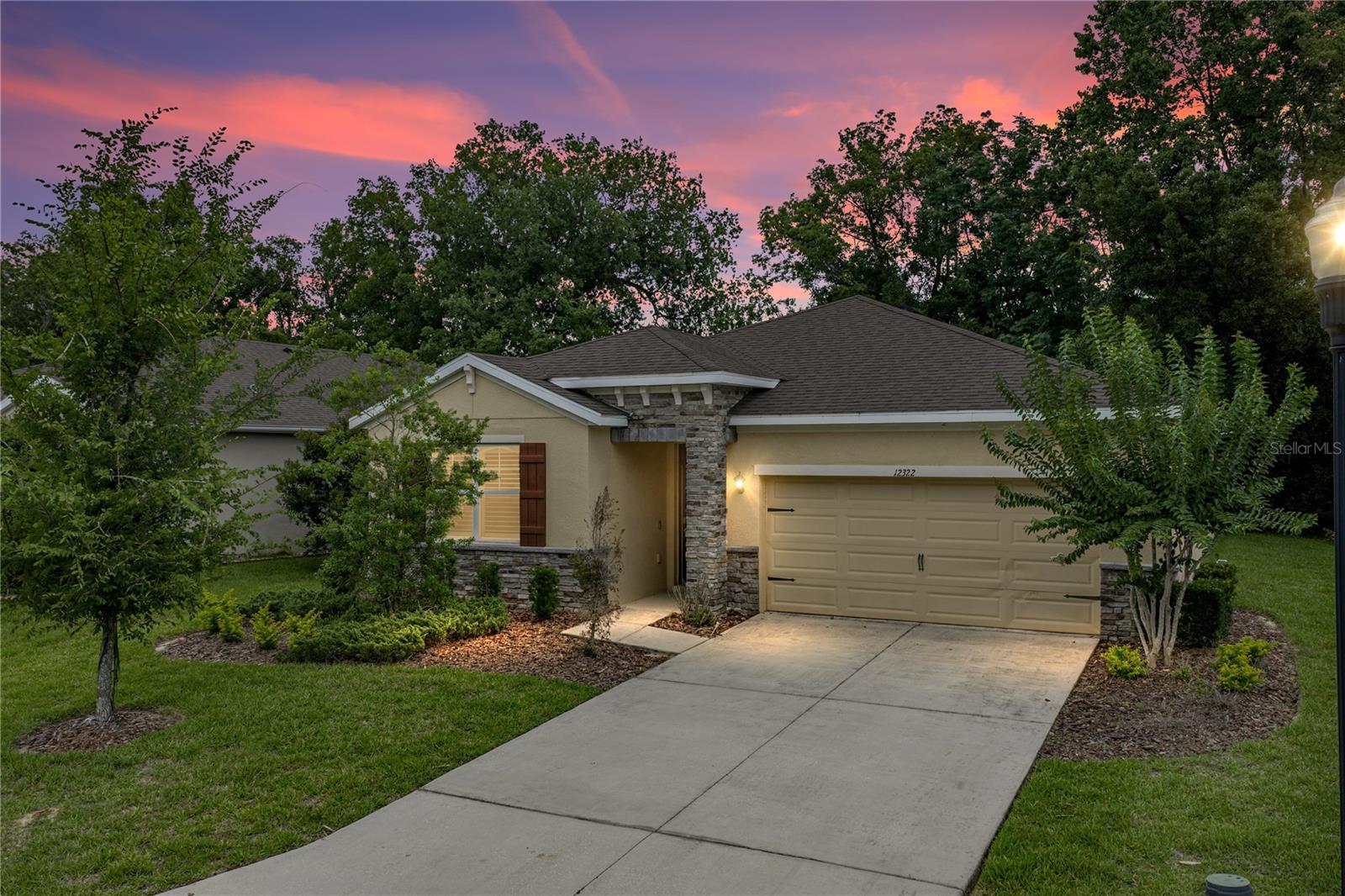 Virtually Staged. Near the gated entrance of Eastpointe at Lake Jovita, with neighbors on only one side and a wooded backyard for privacy, this 2020 built 2 bedroom + office, 2 bath, 2 car garage home offers a thoughtful layout, low-maintenance setting, and access to one of the area’s most desirable amenity-filled communities! Lush tropical landscaping, stone-accented curb appeal, a covered entryway, and HOA-maintained lawn care create an inviting first impression before the home opens into a bright, open floor plan. Inside, the main living areas connect with ease, creating a layout that feels open without losing warmth. The living room features a stone accent wall with an electric fireplace, adding an elegant focal point to the heart of the home. Nearby, the dining room extends outdoors through sliding glass doors, while the kitchen overlooks the main living space and keeps everything connected for meals, hosting, and cozy nights at home. The kitchen is well appointed with granite countertops, a large central island, stainless steel appliances, a stylish backsplash, and plenty of cabinet and pantry storage. A nearby laundry room helps to make everyday chores a breeze. The 12x10 open bonus room gives the floor plan valuable flexibility. Use it as a home office, play space, formal sitting room, reading area, or add doors to create an additional bedroom if needed. Privately tucked away from the secondary bedroom, the primary suite features plush carpet flooring, two large walk-in closets, and an ensuite bathroom with dual granite-topped sinks, a water closet, and a walk-in shower with bench seating. Across the home, the second bedroom sits near the additional full bathroom with a tub/shower combination, giving guests or family their own comfortable space. Out back, the covered and screened porch provides a peaceful place to unwind while enjoying the private wooded landscape just beyond the home. Eastpointe at Lake Jovita gives residents a gated setting with access to Lake Jovita amenities including a playground, walking trails, dog park, pickleball, and basketball. Additional membership options are available through the Lake Jovita Golf and Country Club, with access to two world-class 18-hole golf courses, a Jr. Olympic-size swimming pool, fitness center, restaurant, and more. Call today to schedule your private showing and see what makes this home and community such a special place to live!