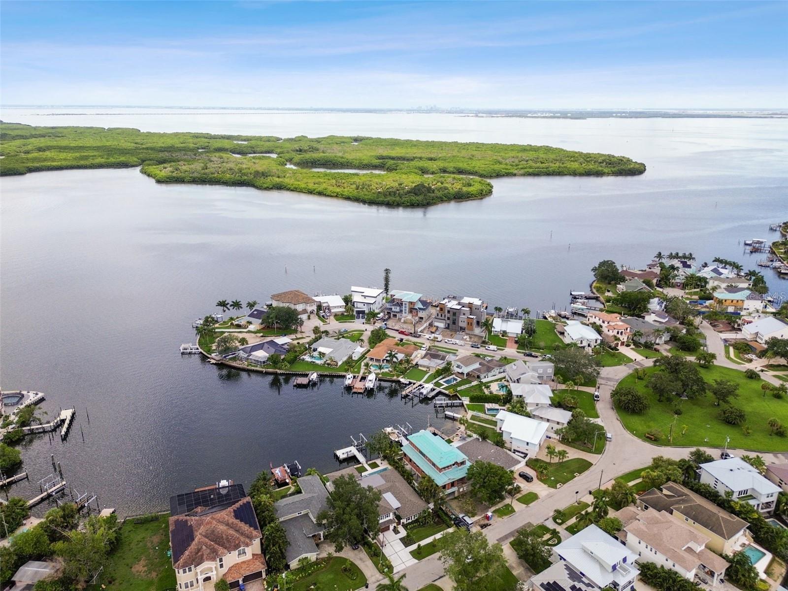 One or more photo(s) has been virtually staged. This fully renovated 5-bedroom, 4.5-bath, 2-car garage pool home in Arrowhead Estates, one of St. Petersburg’s most sought-after neighborhoods, offers an exceptional coastal living experience with direct access to open water. Positioned on a protected cove along Tampa Bay, the property features panoramic views of Weedon Island Preserve and the popular sandbar frequented by boats and kayakers. The complete 2026 renovation has transformed this home into a modern haven with a chef’s kitchen and custom-designed bathrooms featuring natural stone countertops, hand-painted tiles, and exquisite mosaic inlays. The home includes 2022 new plumbing, electrical systems, roof, hurricane windows anddoors, pool, seawall, dock, and a 13,000# boat lift with the upgraded cable retention system (CRS). The interior boasts a 5-bedroom split floor plan with water views from the main living areas, master suite, and a luxurious second-floor guest suite. Shell stone tile and beautiful hardwoodfloors run throughout the home. High-end amenities include a Monogram cabinet refrigerator, induction cooktop, double oven, dishwasher, pot filler, wine reserve/beverage center, Monogram refrigerator drawers and ice maker, and smart home features that allow control of security, audio, and climate systems. Outdoors, enjoy a large shell inlayed paver patio, heated saltwater pool, hot tub, and a full composite dock with a fish cleaning station. The covered patio extends into a full outdoor kitchen equipped with top-tier appliances, including a Blaze Marine stainless steel grill and Monogram wine and beverage center, perfect for entertaining against the backdrop of unobstructed water views and professionally landscaped grounds. If all this is not enough, this home is located near top-ratedschools, parks, and just minutes from downtown St. Petersburg and Tampa Airport, this home offers both luxury and convenience in a serene waterfront setting. Arrowhead Estates further enhances resident experience with a centrally located private park. This home captures the essence of a luxurious Florida lifestyle in one of Tampa Bay’s premier locations. Call today for your private viewing as homes like this do not come aroundoften.