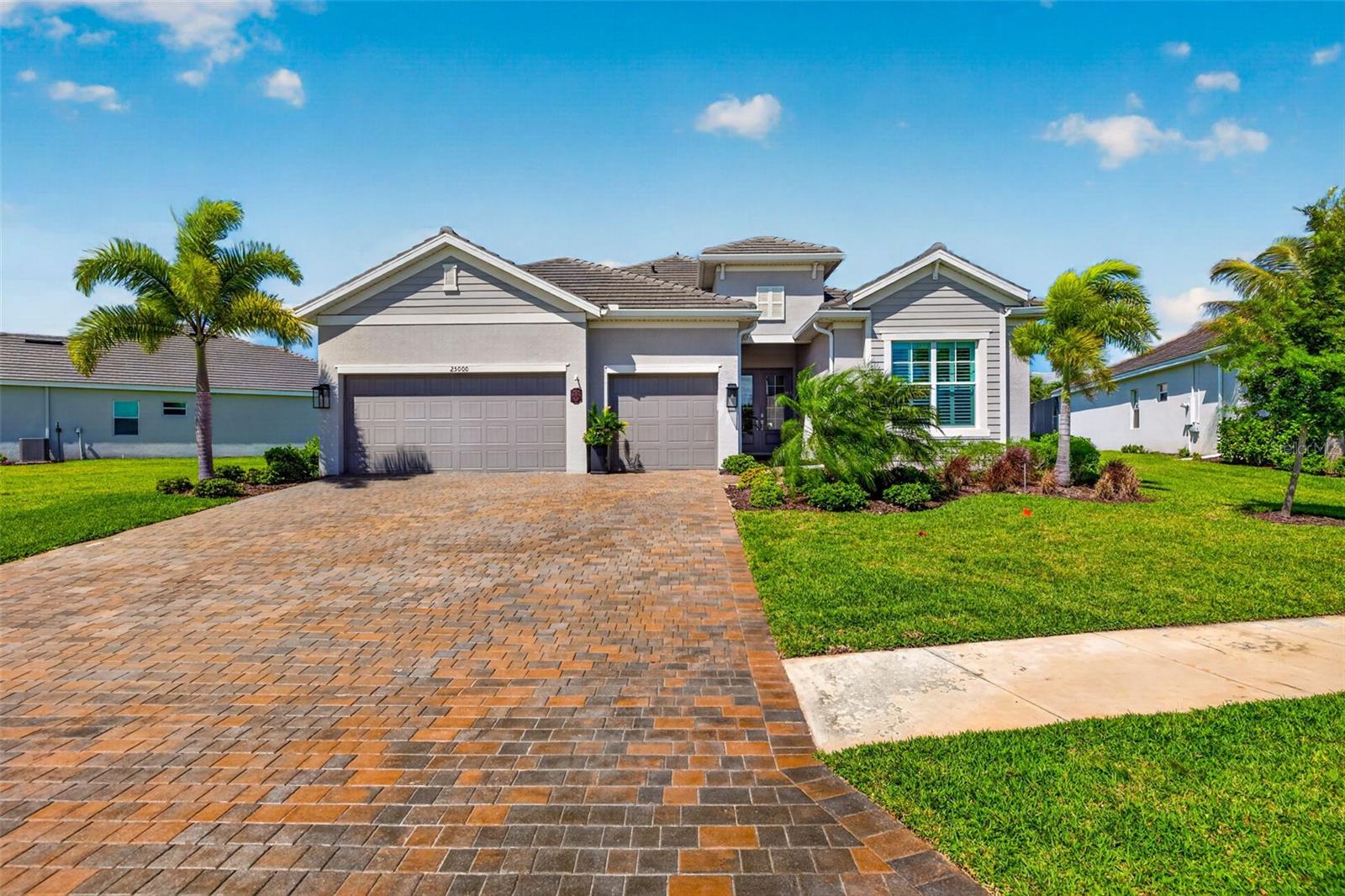 Welcome to your new home within the gates of Heritage Landing Golf & Country Club. Golf membership included!! From the moment you pull into the expansive brick-paver driveway, you’re greeted by striking curb appeal and manicured tropical landscaping. Walking in through the glass-inlay front doors, the foyer immediately opens into a wide, airy great room where the high ceilings and natural light lead your eyes straight through the heart of the home toward the water views out back. Moving through the foyer and to the main living areas, you’ll notice the crisp white walls, designer lighting, and plank tile flooring that flows throughout the home. Off to the left is your living room crowned by a recessed tray ceiling and anchored by a custom built-in entertainment center featuring a sleek electric fireplace and a natural wood mantel. This space flows seamlessly into the gourmet kitchen—a chef’s dream equipped with white shaker cabinetry, granite countertops, and premium stainless steel appliances, including a built-in wall oven and microwave. The oversized island with a breakfast bar and elegant pendant lighting serves as the perfect social spot for friends and family. As we pivot past the living area, towards the rear of the home, you are led to the primary bedroom. The room is generously sized and large windows allow plenty of natural light to fill the room. The ensuite bathroom is meticulously designed with granite countertops, a glass enclosed shower and dual sinks. Connected to the bathroom, you'll also find 2 separate and spacious walk-in closets. Last feature in this room that can't go unnoticed are the doors leading out to your screened in lanai. This screened in space is detailed with a decorative wood ceiling and gives plenty of room to enjoy endless, private views of the glistening lake. Heading back inside and to the opposite side of the home is where you will find the additional guest bedrooms and a den - giving ample privacy to everyone residing. On one side, you have the den, a full size bathroom and a guest bedroom. On the opposite side of the hallway is the last guest bedroom with an ensuite bathroom and is also where your laundry room and garage access is. While many homes in the community may deal with the "through-traffic" of residents, this home is situated on a quiet cul-de-sac. Plus - if you're looking for a way to travel around the community, the golf cart is negotiable! Outside of your home and within the community, you have many amazing amenities at your fingertips. Those include an 18-hole championship golf course, the aqua range, a heated resort-style pool and spa, pool café with a tiki bar & poolside service, a fitness center, full-service spa, saunas, 6 Har-tru tennis courts, 6 pickleball courts, 2 bocce courts & more! Come check out what the Heritage Landing lifestyle is all about!