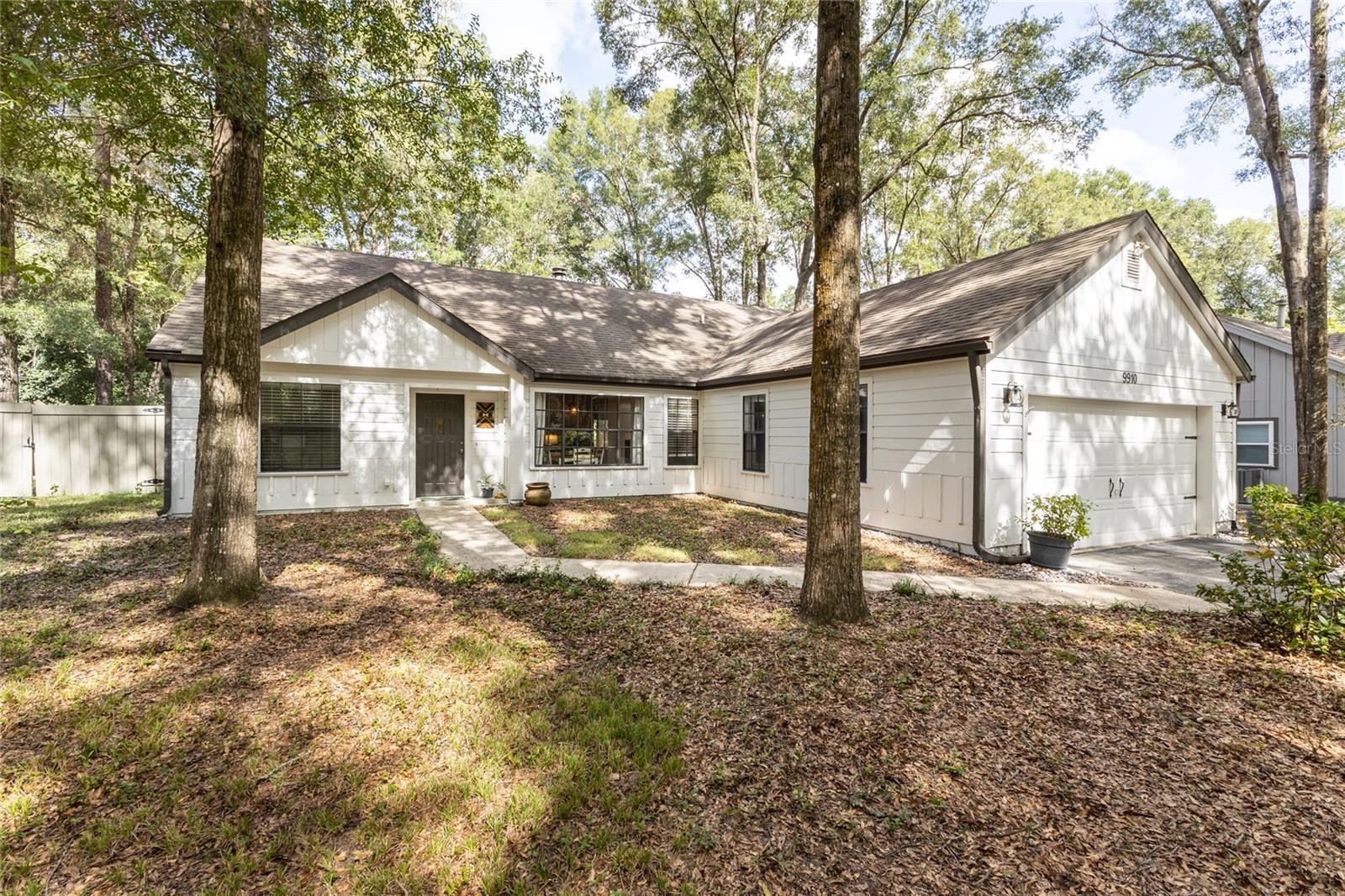 Charming contemporary 4/2 home in Lexington Farms. Dramatic great room with wood-burning fireplace has natural light from double skylights; it opens through double French doors onto the large, enclosed Florida room with triple sliders opening onto the large patio. Ceramic tile floors in main living areas and newer engineered wood floors in all bedrooms. Split floor plan has two bedrooms with one bath on one side and the master and the fourth bedroom or study on the other side of the great room. Kitchen features: wood paneling and pass-through to living room; painted wood cabinets, butcher-block counters, newer Stainless Steel sink & appliances. Fenced yard with paver patio, fire pit, and Florida friendly landscaping. Enjoy the lifestyle of Haile Plantation- including bike trails, mini-parks, and walking paths; walking distance to the Haile Village Center for dining, shopping, and Saturday Farmers market!