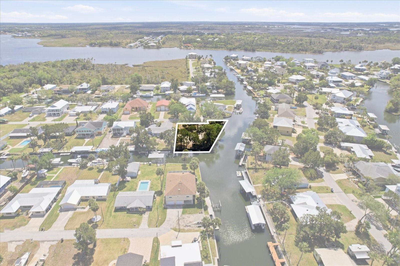 Embrace a rare opportunity to live the waterfront lifestyle! BUILD YOUR COASTAL DREAM HOME on this expansive .42-acre waterfront lot offering an impressive 266 feet of waterfrontage & seawall. This corner lot showcases deep water canals on two sides of the property with panoramic water views. The IMPROVED HOMESITE is ready for your new retreat with city UTILITIES already IN PLACE -including electric, sewer, water, cable, PLUS PAID IMPACT FEES, saving valuable time and money to focus on building the waterfront home you’ve always envisioned! The lot also features a fenced yard, davits, a shared boat slip, and a dock! Enjoy quick, DIRECT GULF ACCESS, making it easy to head offshore for world-class fishing right from your backyard or explore some of the area’s best flats fishing. Spend unforgettable days scalloping with family and friends during the season or cruise the scenic Crystal River on a whim for a relaxing weekend escape. This is truly a boater’s paradise! Tucked away on a peaceful dead-end street, you’ll enjoy both privacy and convenience. Just minutes from Kings Bay and the iconic Three Sisters Springs, where kayaking alongside manatee is part of everyday life. Experience the charm of Florida’s Nature Coast with nearby waterfront dining, unique local shops, and vibrant community events. Located minutes from Homosassa with easy travel to Ocala & Tampa. Opportunities like this are rare, come experience the laid-back Florida lifestyle and make it your own!