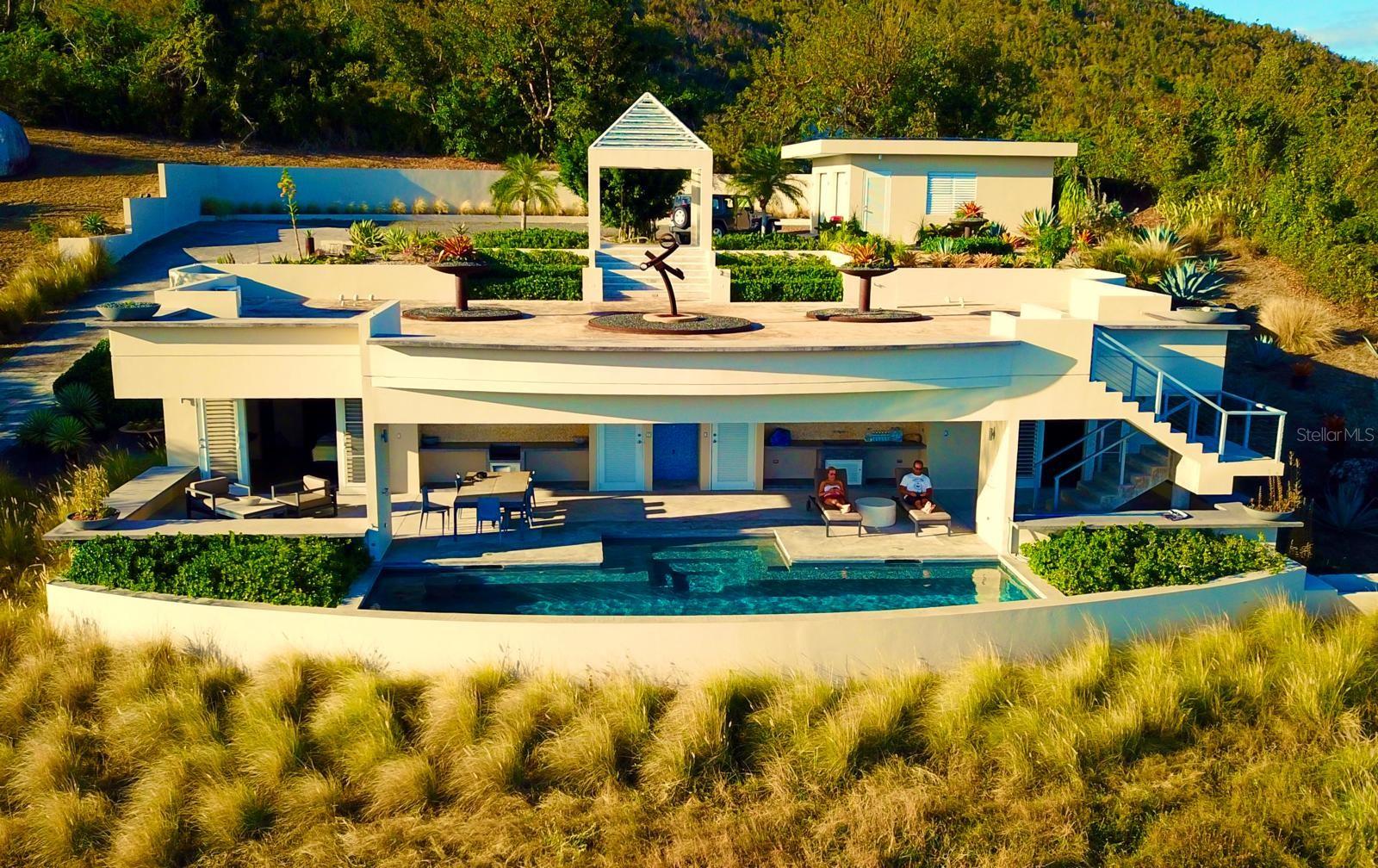 Quinta Jabalí presents a rare opportunity to own an exceptional architectural gem in one of Vieques’ most sought-after locations. Brilliantly designed by renowned architect Stanley Hutchinson, this exceptional estate seamlessly blends modern elegance with natural beauty.

Perched high on a hillside, the home is masterfully positioned to capture sweeping 180-degree views of the Caribbean Sea. The elevated design creates an eagle’s nest effect, offering breathtaking vistas from nearly every angle, while the structure itself is thoughtfully integrated into the terrain — allowing the lush gardens and panoramic views to exist in perfect harmony. This fusion of architecture and landscape makes living here an unforgettable experience.

Set on over two acres of beautifully landscaped grounds, the property is a botanical paradise cultivated over decades by its current owners — both expert landscapers. From the moment you pass through the gated entrance, you're transported into an extraordinary world rarely found elsewhere. The gently curving driveway winds through majestic elephant-sized boulders, rare tropical plants, stately palms, and fruit-bearing trees.

The residence currently serves as a private two bedroom home but was intentionally constructed with the infrastructure to be effortlessly expanded into a four-bedroom layout. The smart floor plan wraps around a serene pool and open-concept outdoor kitchen (grill-ready), ideal for relaxed island living. A detached garage was also designed to be easily converted into an open loft for guests or a studio space.

An expansive grand terrace with a gazebo offers the perfect setting for sunset soirées that transition into starlit gatherings—ideal for entertaining in true Caribbean style.

Located in the exclusive enclave of La Hueca, surrounded by other distinguished estates and adjacent to the Vieques Wildlife Refuge, Quinta Jabalí offers not only privacy and prestige but also proximity to nature’s most stunning landscapes. The property’s carriage-style porte-cochère and timeless design evoke the elegance of a St. Barts estate.

Sustainability and self-sufficiency are key features of this estate, which includes a spacious laundry / storage room, 30 solar panels, tesla powerwalls, two 14,000 gallon cisterns, and eco-conscious infrastructure.

This is not just a home—it’s a legacy property that captures the essence of a luxury island lifestyle.
