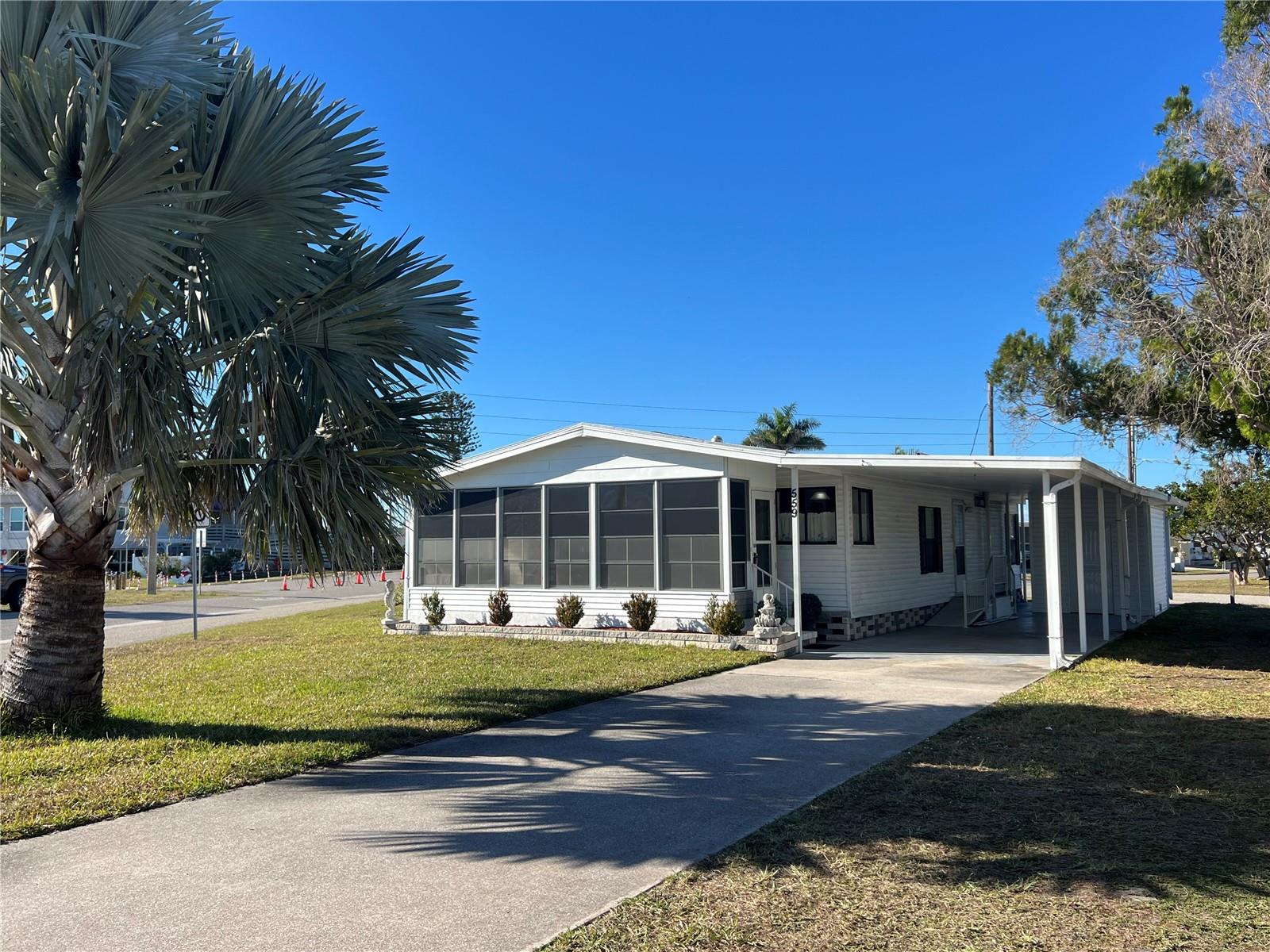Opportunity knocks in 55+ Harbor Cove and location is everything — and this oversized lot delivers! With dual access and parking from both Fleetwood Street and Blackburn Boulevard, plus views of the water and marina right across the street, you’ll enjoy the benefits of a waterfront setting without the cost of a waterfront lot. This furnished 1,100 square foot 1988, 2 bedroom, 2 bath home is being offered AS-IS with some repairs needed but the home’s potential is clear and it is priced accordingly for a quick sale. Both roof and AC unit were updated approx. 3 years ago and subfloors and flooring have been replaced except for the guest bedroom which will need to be done in the future. The HOA will require the buyers to paint the home's exterior, replace a screen and repair a small portion of skirting. Inside, find a good-sized kitchen with lots of cabinets, pantry and breakfast bar open to the dining room with its built-in lighted hutch. The comfortable living room has sliding door access to the lanai creating a bright and inviting space. The primary suite is roomy with walk in closet and an updated ensure bathroom. Plenty of storage in this home and a convenient interior laundry room. Outside, find one of longest driveways in the neighborhood and an upgraded carport and shed. Step right across the street to the two-story clubhouse and make friends easily at dances, entertainment shows, picnics, karaoke, card games and more. Residents here enjoy two heated swimming pools, hot tub, fitness center, craft rooms, bocce, shuffleboard and tennis/pickleball courts. HOA fees are just $175 per month, and annual boat slip rental is only $300, making boating and water adventures surprisingly attainable. Everyday wildlife sightings and some amazing sunsets add to the natural experience. With Gulf access from the marina, beaches, dining, medical services and shopping nearby, this property combines location, lifestyle, and opportunity — a smart buy for anyone looking to enjoy Harbor Cove with marina views and affordable access to the water!