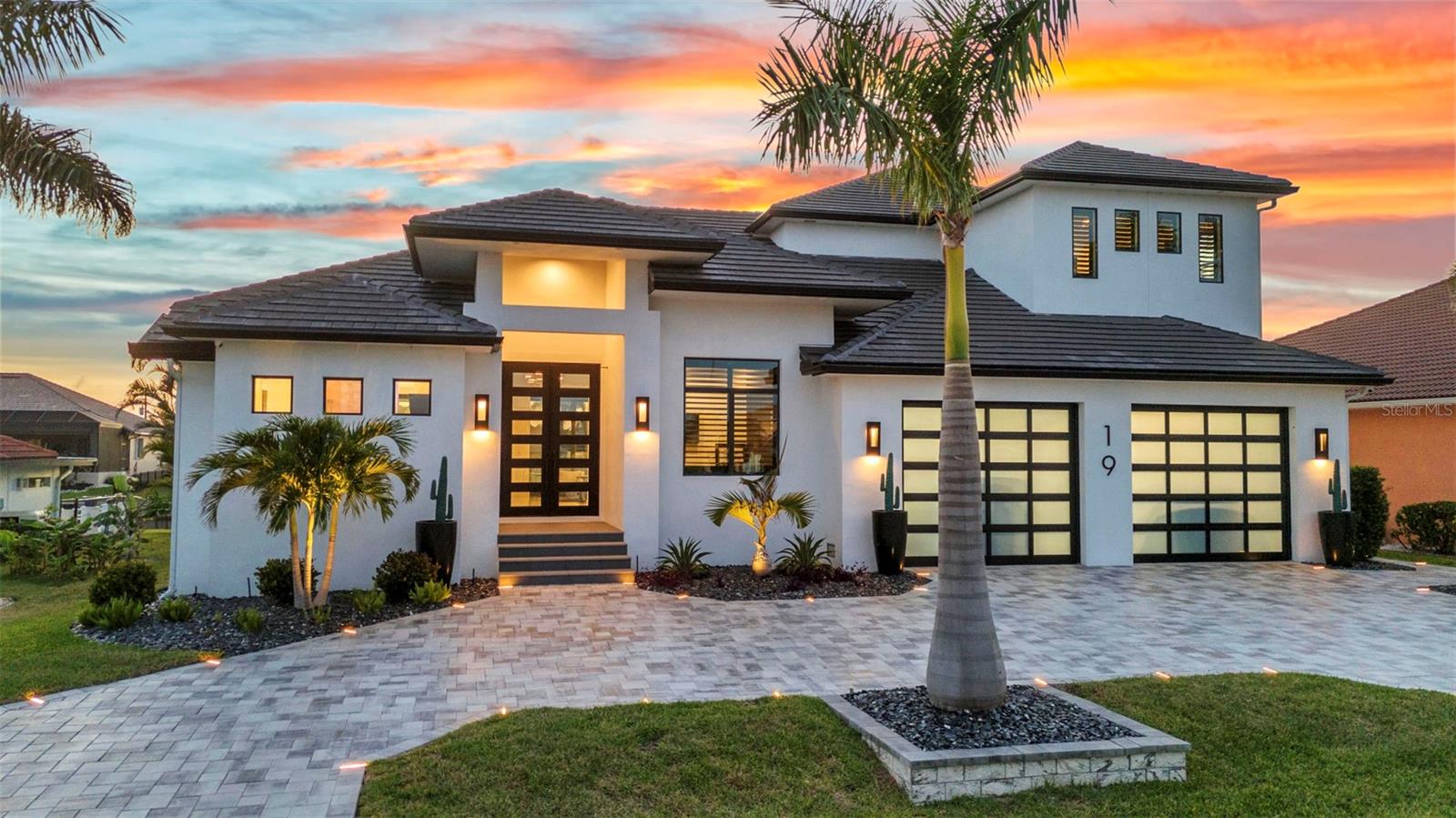 Welcome to 19 Sabal Drive, a striking luxury residence in Punta Gorda Isles where cutting edge design, and waterfront living come together. Positioned just five lots from Charlotte Harbor, this custom home offers exceptional Gulf access, setting the stage for an unparalleled coastal lifestyle.Built for both beauty and durability, this two-story home spans 3,910 square feet and features 4 bedrooms, 6 bathrooms, a home office, an upper-level utility room, a 3-car heated and cooled garage, and a dedicated exterior-access storage room. Hurricane-rated impact glass throughout including custom garage doors.High-end finishes like 24”x48” porcelain tile and custom black hardwood floors add depth and sophistication.At the center of the home is a chef’s dream kitchen equipped with Sub-Zero refrigeration, a JennAir micro/oven, induction stove top, and dishwasher a double-faucet 60" sink, no seam quartz counters and backsplash and sleek custom cabinetry. Tucked behind the kitchen a butler’s pantry offers tons of extra prep space, a True commercial-grade double glass-door cooler, modern cabinetry, and a wall-mounted hydration station. For entertaining, the wet bar includes True black stainless under-counter coolers and ice maker for seamless hosting.The wine room, styled with dramatic black hardwood, houses up to 240 bottles in a climate-controlled showcase.
Step outside to your private resort-style retreat, featuring an oversized pool and spa surrounded by a custom porcelain deck with hidden drainage. The outdoor kitchen boasts weatherproof cabinetry, a 48" sink with disposal, a built-in grill, oversized burner, 4,000 CFM vent hood, and 2 granite fire boxes. LED rope lighting on the pool cage and Hunter Douglas auto blinds on 10' sliders elevate every moment spent outdoors.For boating enthusiasts, the property includes a 30,000 lb lift with auto cover for a 40' boat, dual jet ski lifts, and an expansive dock.
Additional upgrades throughout the home include a central air fragrance system, six Kohler Veil smart bidet toilets, electric fireplaces, Euro-style outlets and switches, high-end lighting fixtures, a 7-zone irrigation system, built-in power washer, tailored wall treatments and thumbprint entry locks. The garage doubles as a fitness zone with professional equipment and epoxy floors, while the exterior-access storage room offers ample space for tools and recreational gear. Smart home integration brings convenience and comfort with control over the 9-zone Sonos system, lighting, shades, HVAC, security, and more, all from your phone.
This isn't just a home it's a masterpiece of innovation, luxury, and lifestyle on the water.