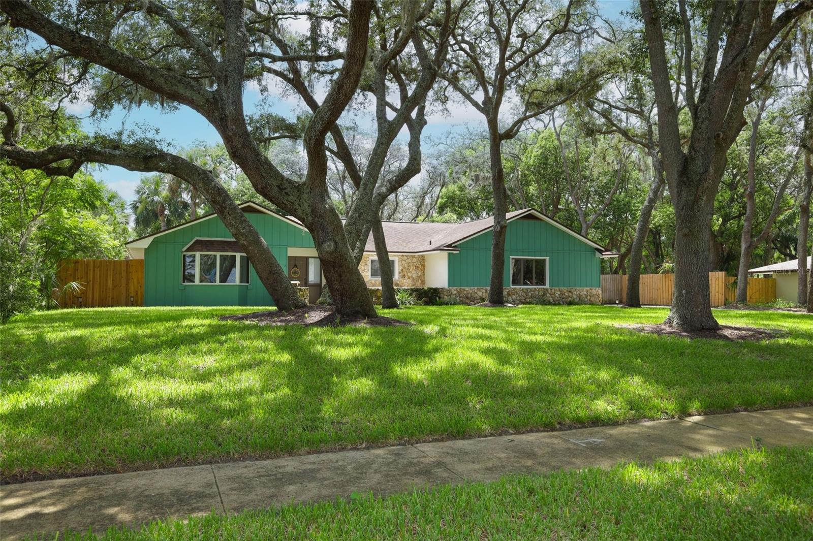 Welcome home to this thoughtfully updated 5-bedroom, 3-bath residence nestled on an oversized lot beneath a canopy of mature trees in the highly sought-after Tuskawilla community of Winter Springs. Offering over 2,500 square feet of thoughtfully designed living space, this home features a desirable split floor plan with the primary suite tucked away in its own private wing, creating a peaceful retreat from the secondary bedrooms. At the heart of the home is the beautifully remodeled kitchen, featuring quartz countertops, updated cabinetry, modern fixtures, updated appliances, and plenty of space for gathering with family and friends. The spacious living and dining areas provide an inviting setting for everyday living and entertaining, while the fully enclosed Florida room serves as a true extension of the home, making it the perfect place to host movie nights, enjoy your morning coffee, or unwind while overlooking the spacious backyard shaded by mature trees. Recent improvements include luxury vinyl plank flooring and baseboards throughout, fresh interior and exterior paint, refreshed landscaping, an updated sprinkler system, a whole-house water softener and filtration system, and two beautifully renovated bathrooms featuring updated vanities, flooring, fixtures, toilets, and shower tile. Additional major updates include a roof replaced in 2018, HVAC replaced in 2020, updated plumbing, and an electrical panel replaced in 2023, providing added peace of mind for years to come. Located in one of Winter Springs' most established communities, residents enjoy a voluntary HOA, optional memberships to Tuskawilla Country Club with golf, swimming, fitness, tennis, and social amenities, nearby Trotwood Park, golf cart-friendly streets, and access to Seminole County's top-rated schools. Conveniently located near shopping, dining, and SR-417, this home offers the perfect combination of modern updates, timeless character, and an exceptional location.