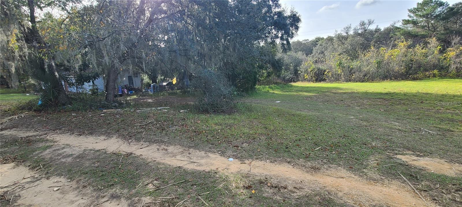 This lot previously had a home on it. Impact fees were paid when the previous home was there. Check with the county to see if any impact fees are needed for what you want to put on the property. There is no need for a well because a private water company provides for this community. This location does not have a homeowners association. So build or set up your manufactured home on this nicely treed lot in a rural location. The Buyers must verify all details of the subject property, and it is recommended to procure their own survey. If you want to drive by, closest house is 17145 SE 251st
