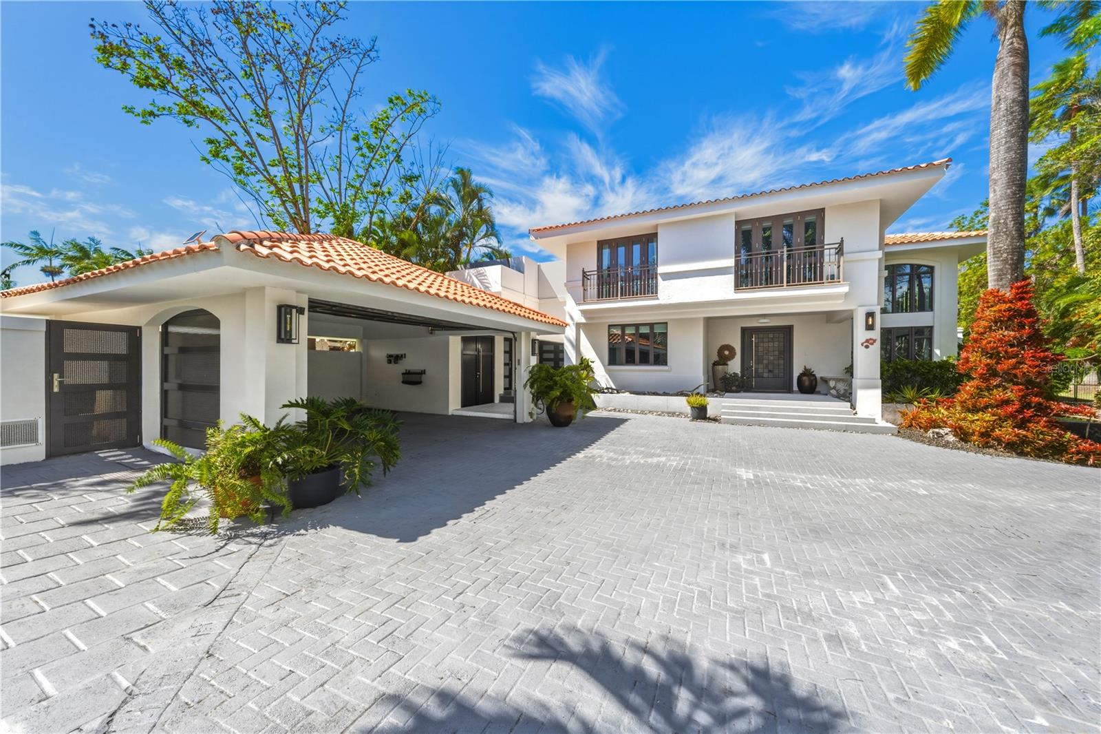 Set within the prestigious enclave of Dorado Beach East, 29 Dorado Beach East is a thoughtfully designed tropical residence distinguished by its scale, privacy, and seamless connection to nature. The property is conveniently accessed through the more secluded north entrance of Dorado Beach East, offering proximity to the beach, Encanto Beach Club, and the Ritz-Carlton Reserve. Arrival is marked by a tranquil, multi-level koi pond at the main entrance, creating a calm and welcoming introduction to the home. Inside, a grand formal living room unfolds with ceilings rising over 22 feet, filling the space with natural light and a sense of openness. The main level is designed for effortless living and entertaining, with a fluid layout that connects the formal dining room to a more intimate family room, highlighted by a bay window overlooking lush greenery. The expansive kitchen serves as the heart of the home, featuring a generous center island and a separate breakfast area with its own wet bar, equally suited for relaxed mornings or more formal gatherings. Two well-appointed bedrooms with ensuite bathrooms complete this level. The second floor is conceived as a private retreat, centered around a charming courtyard filled with potted plants that offers a quiet focal point upon arrival. The primary suite is notably spacious, with 19-foot ceilings and bay windows that invite abundant natural light. Three additional bedrooms, each with its own ensuite bathroom, provide privacy and comfort for guests. What truly defines the home is its relationship with the outdoors. Retractable large-format doors in the living room and kitchen open fully to the grounds, dissolving the line between interior and exterior spaces. Situated on a private corner lot of nearly half an acre, the property is surrounded by mature landscaping, tropical foliage, and flowering gardens that create a serene and secluded setting. The outdoor areas include an infinity pool, a fully equipped summer kitchen with BBQ, and ample seating for comfortable alfresco living. Residents of Dorado Beach East enjoy access to the world-renowned Dorado Beach Resort, which offers an unparalleled lifestyle with championship golf courses, miles of swimmable beaches, nature trails, spa sanctuaries, and a celebrated Beach Club featuring oceanfront dining. Additional amenities include state-of-the-art fitness centers, pickleball and tennis courts, as well as volleyball and basketball facilities. Residents and visitors alike are drawn to the resort’s dedicated water park and year-round programming, while seven on-property restaurants offer a diverse range of dining experiences, from casual beachfront fare to refined culinary destinations. In addition, residents have access to private events hosted exclusively within Dorado Beach, fostering a strong sense of community while preserving the privacy and exclusivity for which the resort is known.