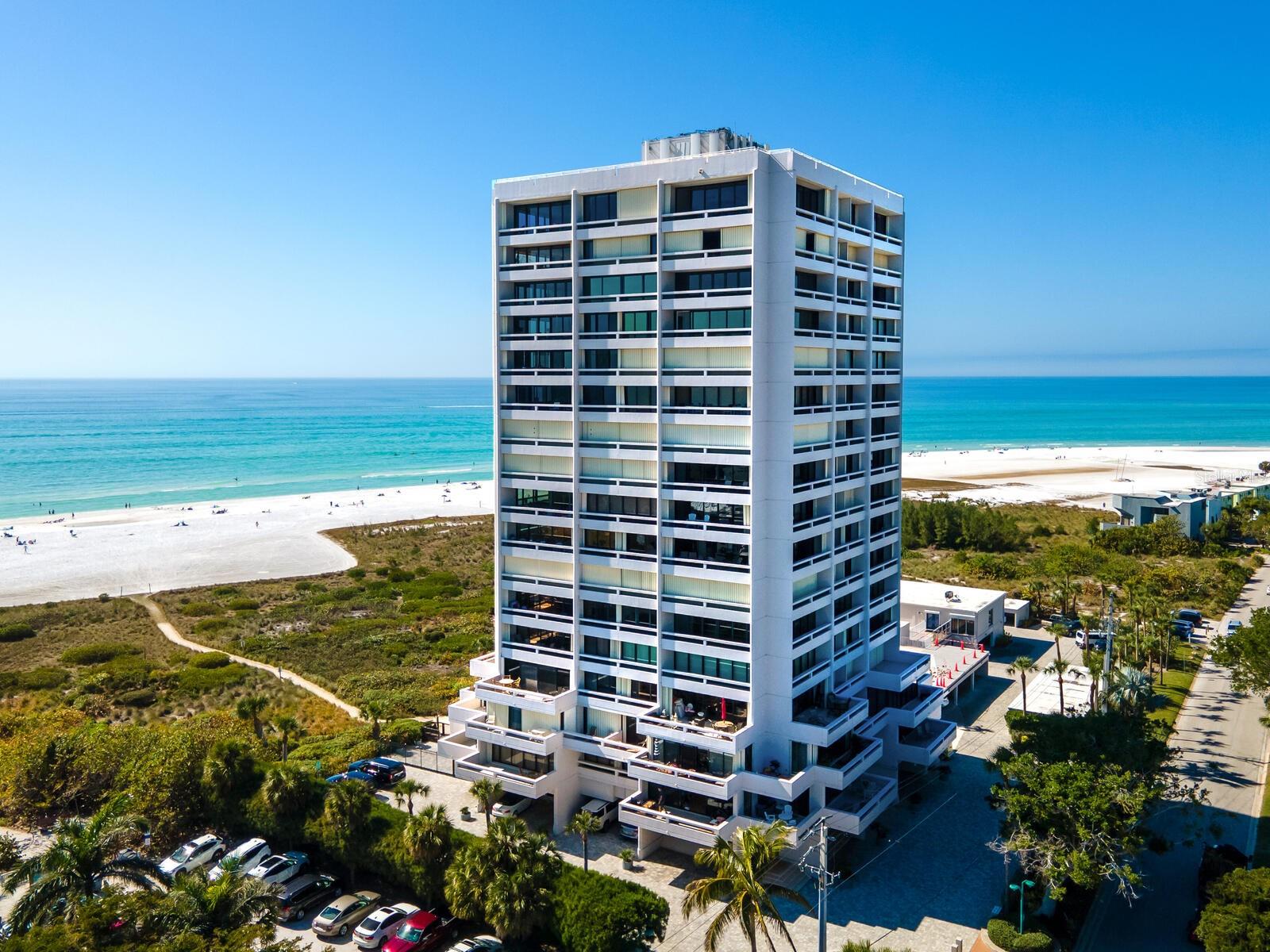 New price! Experience the ultimate in Siesta Key beachfront living. Directly on world-renowned Siesta Beach, rated #1 in the U.S. and #4 worldwide by TripAdvisor, this stunning fifth-floor corner residence captures the essence of luxury coastal living. Recently renovated to perfection, this one-bedroom, 1.5-bath condominium offers a rare combination of modern sophistication, coastal elegance and sweeping Gulf views. Designed by the acclaimed architect Frank Folsom Smith, the iconic Beach Terrace building is an architectural gem. This residence is a standout, meticulously renovated by a designer whose impeccable taste and attention to detail elevate the home well beyond expectation, with a focus on efficient use of space. The result is a move-in-ready retreat where every inch reflects exceptional craftsmanship and thoughtful design. Go inside to discover two walls of wrap-around, floor-to-ceiling impact-rated sliding glass doors that open to three private balconies, expanding the total usable space to 1,284 square feet, immersing you in stunning views of the Gulf’s turquoise waters and legendary white quartz sand. The chef’s kitchen is a masterpiece, featuring Quartzite countertops, custom European cabinetry, high-end stainless steel appliances and an expansive island that anchors the open concept living area. The spacious great room, bathed in natural light, includes a custom Murphy bed for overnight guests and provides a setting to enjoy Siesta Key’s radiant sunsets. Every element of this home is designed for comfort and style, from the serene primary suite to the elegant finishes throughout. The primary bath reflects a flawless balance of form and function. Featuring European cabinetry, a glass-enclosed walk-in shower and spectacular floor-to-ceiling tilework, this serene space exudes modern elegance. Every detail, from the sleek fixtures to the artful tile patterns, has been thoughtfully curated to create a spa-like sanctuary that complements the residence’s sophisticated coastal aesthetic. Additional improvements include a new air conditioning system with updated ductwork, new electrical upgrades and a new water heater, ensuring comfort and peace of mind for years to come. Within Beach Terrace’s exclusive enclave, residents enjoy the security of a controlled-access lobby, the convenience of an on-site manager, and premium amenities including a heated saltwater pool overlooking the Gulf, fitness center and community lounge. Go outside and you’re just moments from Siesta Key Village, where you’ll find inviting boutiques, beachside cafés and vibrant local dining. With the beach at your doorstep, a car becomes optional. And when you crave a touch of city life, downtown Sarasota’s acclaimed cultural scene, restaurants, galleries, opera, ballet, and theaters, is just minutes away across the north bridge. This is more than a residence, it’s a rare opportunity to own a beautifully reimagined piece of paradise, where luxury, location and lifestyle converge to create an extraordinary beachfront experience on Siesta Key.