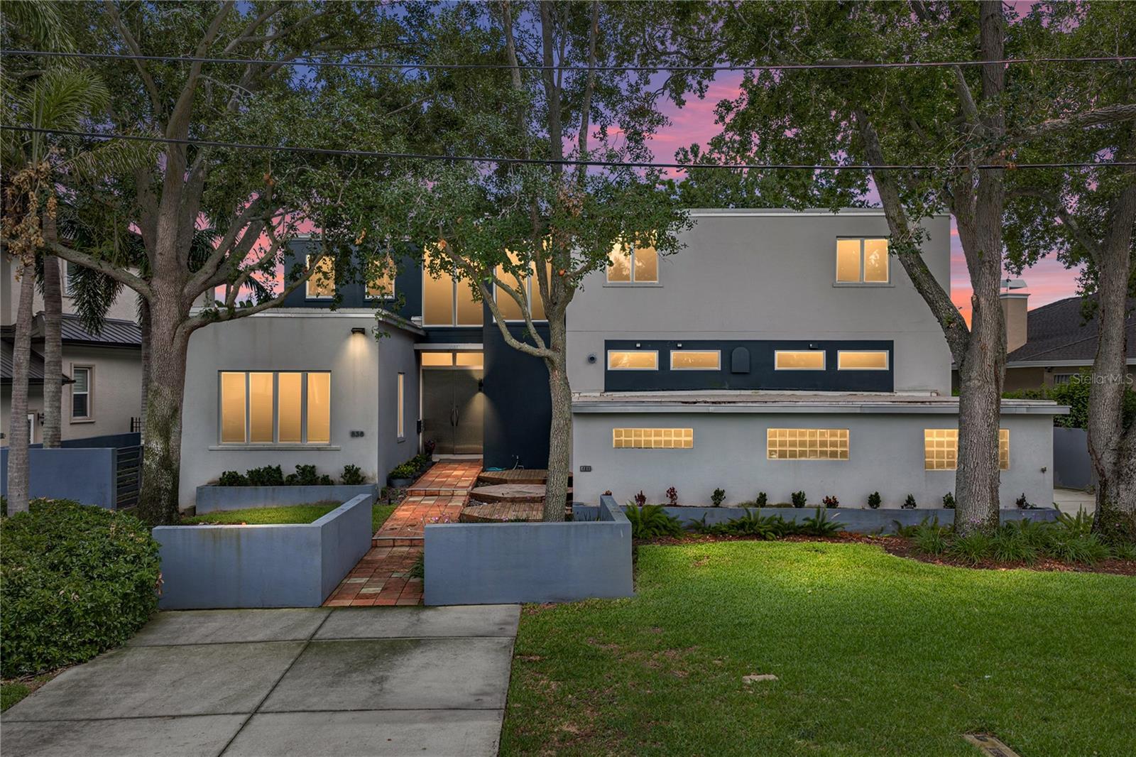 Designed by renowned Architect William Harvard Jr and built in 2005, this waterfront modern marvel boasts a beautiful layout and a wonderful view in a highly desirable location of Snell Isle. This home was built like a bunker. The home sits above the flood plane, and the exterior walls are concrete block with filled cells, and with structural steel studs. Interior walls are also concrete block with prestressed concrete planks for ceiling and roof support. The floor construction is concrete under the beautiful hardwoods. The home also features a new roof in summer of 2024, hurricane windows and doors throughout, and a whole house generator so you don't lose power in any storm. Beyond the best construction, this is an artist's home, where natural light fills the spacious rooms, and provides grand wall space with 10' ceilings on the first floor. Enter through the custom metal front doors into a two story foyer. To the left is a beautiful formal living room and large hall closet that could be turned into a butler's pantry or wet bar. The large first floor den also features a full bath, and could be used as a downstairs primary or guest room. For the ultimate entertainer, the formal dining room connects to the chef's kitchen, featuring a professional 6 burner Thermador range and large eat-at island with custom red quartz. The cozy family room features a gas fireplace and inlaid wood floors. Every living space features french doors that open to the Spanish tiled porch that spans the width of the home, the ideal place to enjoy the morning air or evening beauty of Coffee Pot Bayou. When it is time to retire for the night, take the elevator to the second floor, featuring 8' ceilings, wood and carpet floors. Three bedrooms upstairs all feature en-suite bathrooms with cast iron tubs, custom vanities and countertops, and waterfront views. Down the hall is a large laundry room with great storage. The master suite features a large walk-in closet and large bathroom with shower, garden tub, toilet room, dressing area, and custom double vanity. All bedrooms on the second floor have doors to two covered porches, where you can enjoy a morning coffee overlooking your private yard and updated dock on the bayou. The dock was rebuilt in 2024. A massive three car garage has high ceilings and bonus storage areas, and can accommodate a car lover's lifts for multiple vehicles and toys. Just minutes to downtown St Petersburg, this beautiful Snell Isle home was built to last, and its modern design make it timeless. Make your private showing appointment today!