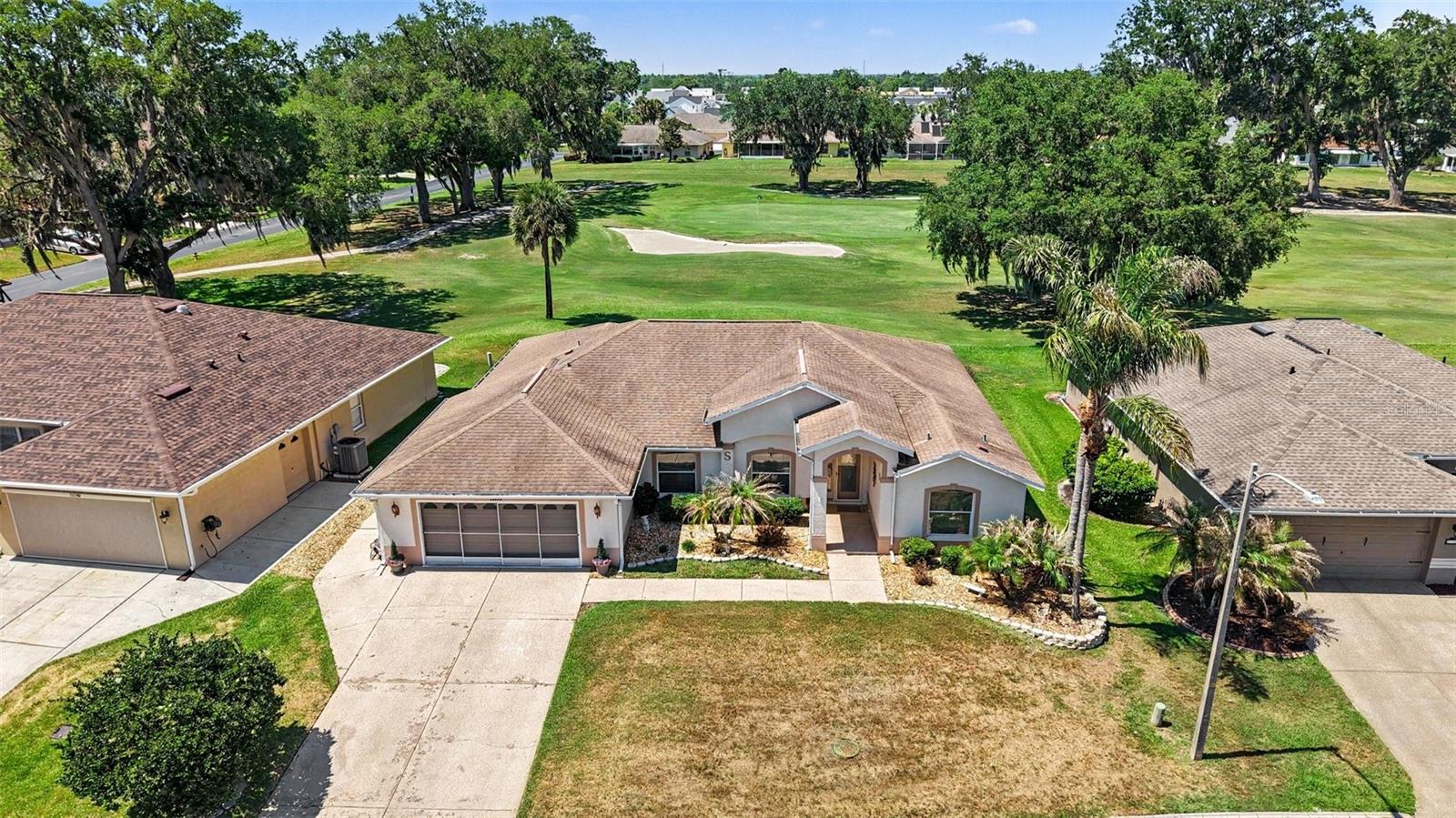 Great View & Located in the sought-after Tampa Bay Golf and Country Club 55+ community, this spacious home offers 3 bedrooms plus a dedicated office and a layout designed for both everyday comfort and hosting extended guests. A decorative glass front entry door sets an inviting tone the moment you arrive. Enjoy beautiful views overlooking the 5th hole of the golf course from the glass-enclosed under-roof lanai featuring A/C vents for year-round enjoyment, as well as an additional outdoor patio ideal for relaxing and taking in the peaceful course setting. The lanai is easily accessed from three separate areas of the home — the living room, primary bedroom, and kitchen/dining area — creating a seamless indoor-outdoor flow throughout the main living spaces. The kitchen features granite countertops and opens to the main living areas for an inviting feel. The versatile dining room space can easily serve as a second living area, sitting room, or flex space to fit your needs. The primary suite offers two walk-in closets, a dual sink granite vanity, garden tub, and separate walk-in shower. A thoughtfully designed guest area includes a guest bath with step-in shower and convenient walkthrough access to the laundry room.  Additional features include a 2-car garage plus golf cart parking with its own garage door, Roof replaced in 2015, Water Heater in 2019, and A/C replaced in 2018. HOA fees in Tampa Bay Golf and Country Club include community amenities, cable, and internet, allowing you to enjoy the active lifestyle this highly desirable golf community offers.