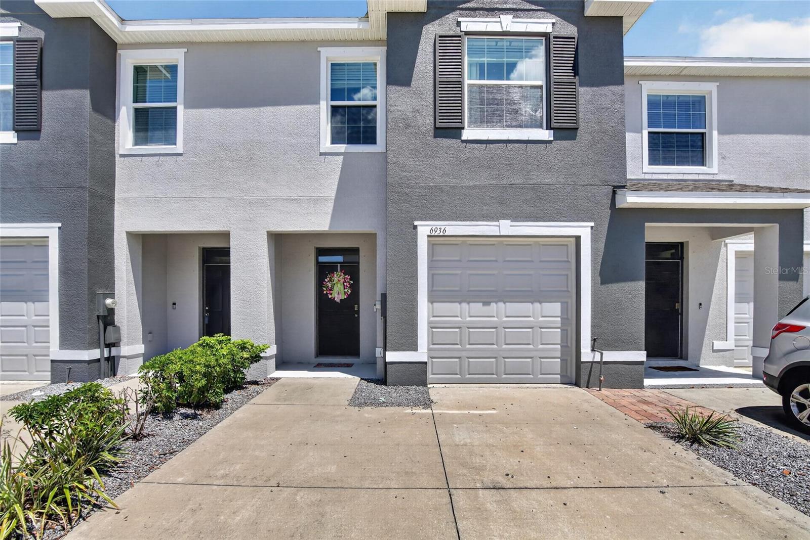 This former Builder's Model is 1707 sq ft, featuring 3 bedrooms, 2.5 bathrooms, and a 1-car garage. Inside, you'll find a well-maintained, thoughtfully designed layout featuring ceramic tile, hardwood floors in the hallway, and carpet in the bedrooms and family room. The first floor features a convenient half-bathroom for guests, granite countertops, and durable all-concrete block construction on both floors. The home also features a spacious screened-in patio overlooking a peaceful wooded area, ideal for relaxing or sipping your morning coffee. Upstairs, you'll find two secondary bedrooms at the front of the home and one full bathroom. The primary suite is privately located at the rear, offering a great-sized bedroom and an en-suite bathroom. Located in the gated community of Osprey Lakes, residents enjoy a prime location just minutes from I-75, I-4, 275, 301 HWY, and the Crosstown Expressway, with easy access to hospitals, shopping, dining, and family-friendly entertainment. Even better—NO CDD and a low HOA, making this an excellent opportunity for homeowners.