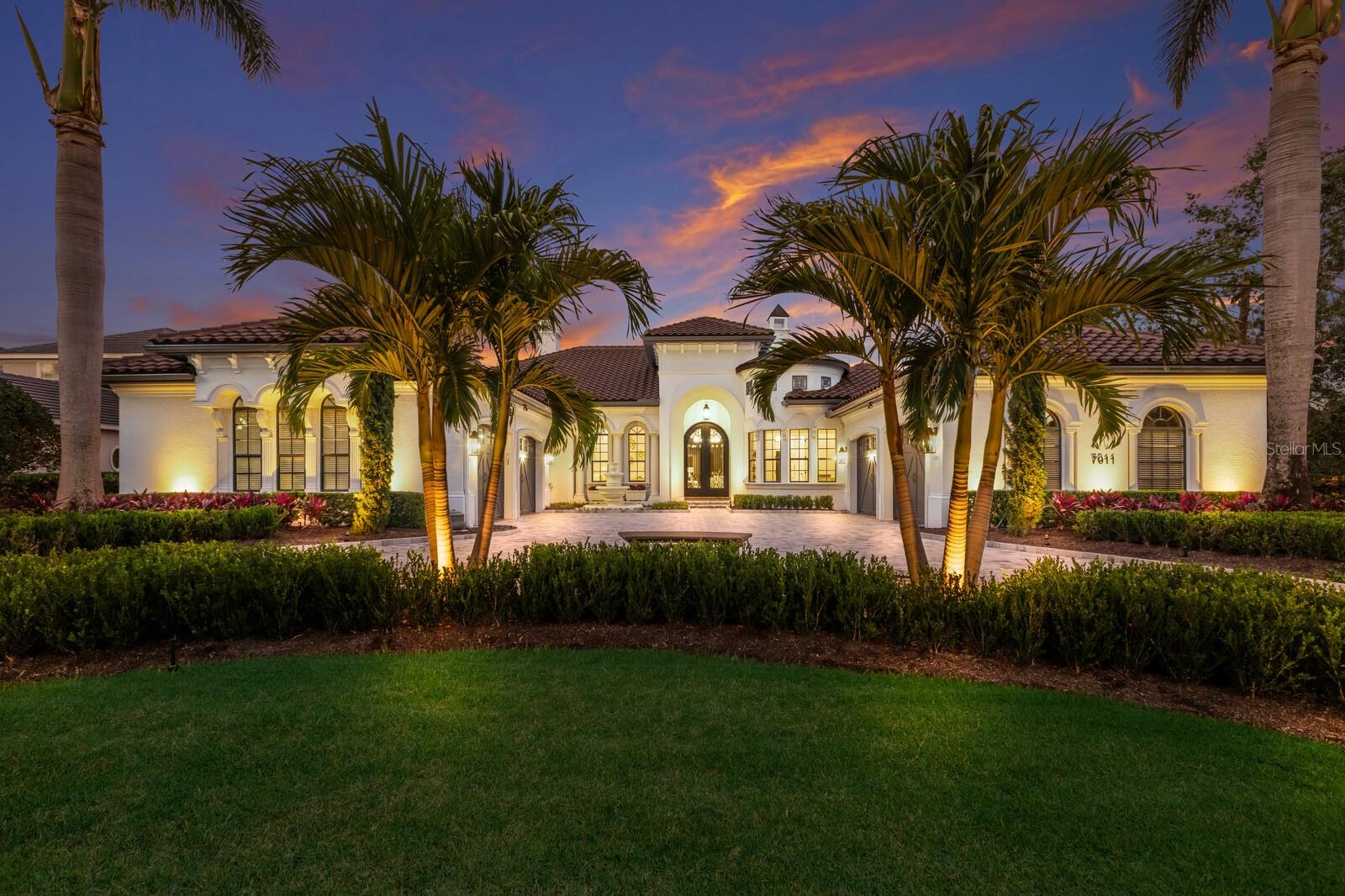 One or more photo(s) has been virtually staged. Welcome to 7011 Belmont Court in Lakewood Ranch Country Club.  This custom-built, single-story Lee Wetherington home is fresh off an extensive interior & exterior renovation. The home offers 6,615 total square feet (4,718 sq ft under air) of exquisite living space, featuring 4 spacious bedrooms (3 en-suite), 4 1/2 designer bathrooms, and oversized 4-car garage. The new barrel tile roof, new paver circular drive, and fresh exterior paint set the stage for the impeccable craftsmanship found within. Inside, wide-plank (10 ¼”) European white oak engineered hardwood flooring flows throughout. The heart of the home is the stunning chef’s kitchen, where every detail has been elevated. Outfitted with top-of-the-line Thermador appliances, including a professional grade 6-burner gas cooktop with griddle, double ovens, microwave, wine fridge, and dishwasher, the kitchen is as functional as it is stylish. Sleek exotic quartz countertops, a waterfall-edge bar, continuous backsplash, two deep Kraus sinks with coordinating faucets, and new reverse osmosis system complete this culinary haven. Retreat to the spa-inspired primary where luxury abounds. With disappearing sliders to the pool & spa, and a large sitting area, the owner’s suite will surely be a haven to retire to. The en-suite bath showcases marble floors in the sprawling walk-in shower with multiple showerheads, rain and handheld fixtures, linear drains, and custom marble niches. Guest bedrooms 2, 3 and 4 are located on the north wing and each bedroom has its own full bath lavishly appointed with Calcutta quartz, new fixtures, new sinks, new commodes, and opulent porcelain tile ensuring a luxurious cohesive feel throughout. Guest suites 2 & 3 both have separate spacious sitting rooms for extra comfort and enjoyment. Family and friends will love to gather in the vast bonus room boasting 30’x 18’5” and featuring a 22’ regulation size professional shuffleboard game table.  The disappearing sliders allow the party to continue to the covered lanai space for dining al fresco in front of the natural gas fireplace. . Host with ease in the new outdoor kitchen, complete with new granite countertops, new gas grill with vent hood, sink, and designer fixtures. Step outdoors, where an entertainer’s paradise awaits. The resurfaced pool features all brand new Wi-Fi-app controlled Pentair equipment, new waterline tile, new large-format shell stone pavers, and a fully re-screened and repainted pool cage. Walk out into a one-of-a-kind private backyard boasting close to 5,000 sf of endless family fun and and/or your pet’s spacious playground.  Additional upgrades include: two brand new Rheem HVAC systems, two new hot water heaters, blown-in insulation, new interior lighting and designer ceiling fans, electronic dog door with ramp for pet access, and epoxy garage floors. Located in one of Florida’s premier master-planned communities, Lakewood Ranch Country Club members have access to four golf courses, three clubhouses, 20 lighted tennis and pickleball courts, a fitness center, Olympic-sized pool, and recreational amenities. Note the low HOA fee of just $150/year. Minutes from Waterside Place, UTC shopping, Benderson Park, and top-rated schools, this one-of-a-kind estate embodies the perfect balance of privacy, opulence and convenience.
