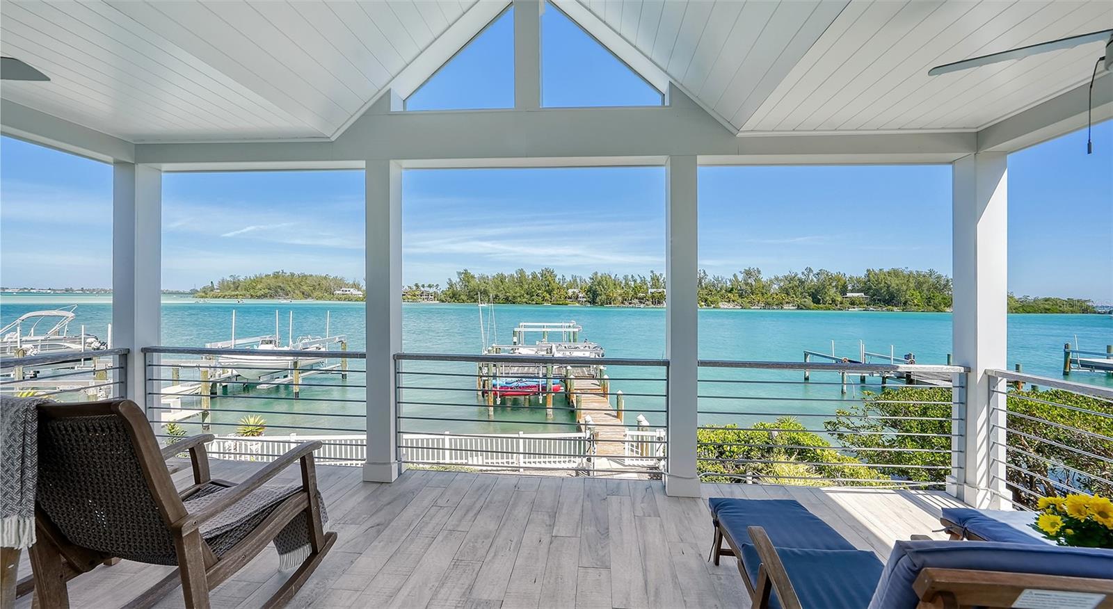 This exquisitely renovated waterfront residence offers breathtaking “Big Bayfront” views and boasts three boatlifts, catering perfectly to boating enthusiasts with quick access to the Gulf of Mexico for fishing or leisurely cruises. Alternatively, if your preference is to unwind and soak in the serene surroundings, the numerous terraces and expansive dock provide idyllic spots to bask in the beauty of the shimmering blue waters and breathtaking sunrises, making this home an ideal retreat for relaxation and enjoyment. This open floor plan basks in natural light throughout with many cozy spaces to enjoy waterfront views from every corner. A large dining room adjoins the breakfast bar in the well-appointed kitchen which includes a Viking sub-zero fridge/exhaust fan and custom-designed buffet cabinetry with glass inset cabinet doors to show off all your crystal for entertaining. Each of the 2 guest suites enjoys a serene bath and custom closets. Take the elevator up to the luxurious owner’s retreat, where the voluminous ceiling transports you to a 5-star resort suite experience. A coral-ensconced fireplace adds a touch of sophistication. "Wow" is the word that comes to mind as you step onto the owner’s suite terrace and gaze for miles at the azure waters where the Dolphins feed every evening at dusk, as you admire the allure of vibrant sunsets and the peacefulness of open water. The lavish owner’s suite bathroom has a custom barn door for privacy with exquisite detail and cabinetry throughout. The wet bar wardrobe-lounge is a great space for unwinding after being on a boat all day or preparing for a night out at one of the excellent dining venues within a short distance. Large hurricane sliders open all the way onto the expansive patio for enjoying covered entertaining as you watch the dolphins play and boats sail by. The new pool and spa, built to VE highest standards in 2019, includes travertine decking upon which sits several chaise lounges for relaxing while soaking up the sun and sipping cool beverages. The stunning guest house, located above the oversized 3-car tandem garage, includes a sleek mini-kitchen, a large great room with soaring ceilings, and a spacious bedroom with an elegant coral stone surround fireplace. Glamorous French doors lead to a patio above the pool where you can watch the sunrise as you enjoy your morning coffee. The property features professional landscaping for minimal maintenance and saltwater-resistant vegetation. The extra-large dock (grandfathered) with deep-water dockage includes 3 boat lifts: 5,000 lb, 10,000 lb, and a new 24,000 lb six-piling boat lift. The large, 3-door garage has several workbenches, storage, shelving, 2 backup generators, and plenty of room for kayaks, a golf cart, or other beach toys. An electronic fence surrounds the estate for security and privacy. This magnificent beach property has been beautifully upgraded by the owners, who spared no expense. Upgrades include all new (2023) wind-rated windows and doors, 2 new (2023) metal roofs, 3 New HVAC systems (2023), new 850-SF addition (2019), totally renovated 850-SF second-level primary bedroom, bathroom, and bar area as well as new upper and lower decks on the waterside. Home is turn-key furnished and move-in ready. Don’t miss this opportunity to live the Longboat Key lifestyle here in Paradise, Just bring your flip-flops & move right in !