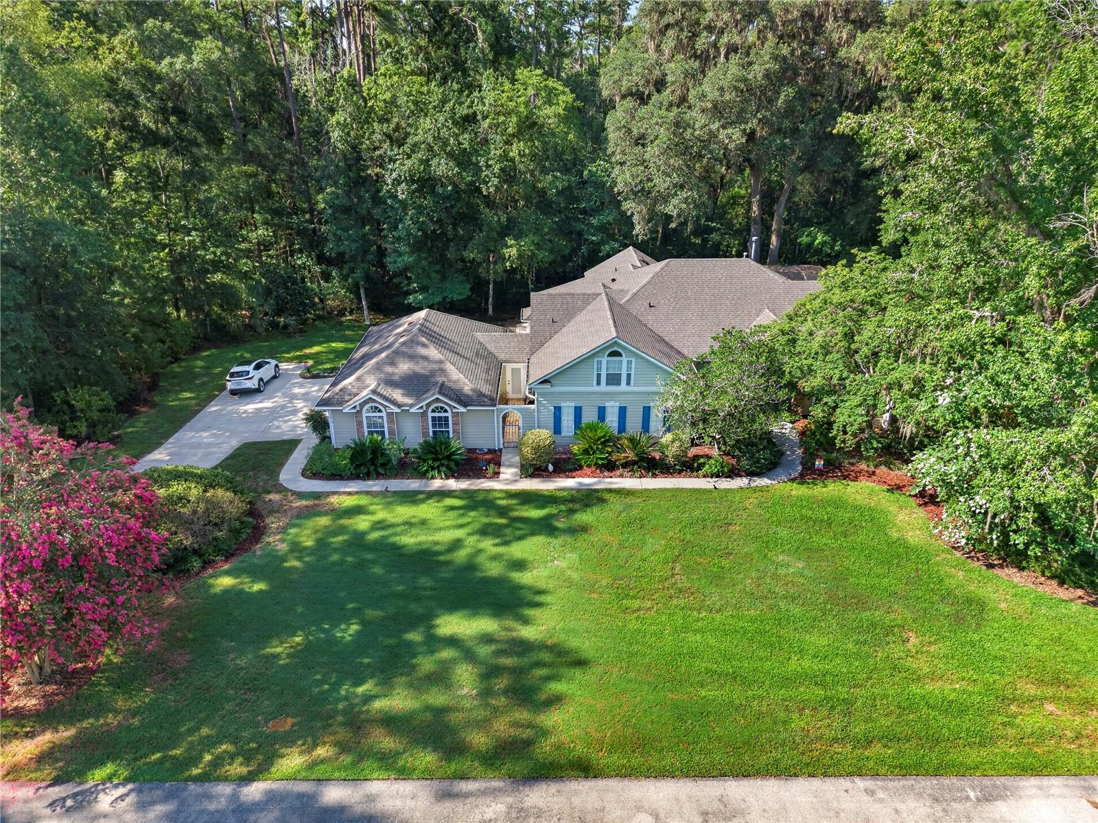 4 Bedroom 3.5 Baths Situated on a beautifully wooded 1.1 acre lot in the gated Plantation Grove at Fletcher’s Mill community, this 3,655 square foot home offers a rare blend of privacy, space, and convenience in West Gainesville. Built in 1996 and thoughtfully updated, the property is designed for both everyday comfort and exceptional entertaining—just minutes from the shopping, dining, and amenities of Town of Tioga.
Inside, oversized rooms and abundant natural light create an inviting atmosphere. The floor plan includes four bedrooms, three and a half bathrooms, two separate living areas, a formal dining room, a dedicated office, and an impressive 13 seat surround sound theater.
The renovated kitchen (2024) is a standout feature, offering new appliances, a double oven, quartz countertops and backsplash, a central island, seating counter, wine bar, and a walk through butler’s pantry. It opens directly to the main living area, where a large gas fireplace and a wall of windows frame serene views of the backyard.
The primary bathroom was fully renovated in 2026 with dual vanities, quartz countertops, illuminated mirrors, and a spacious glass enclosed wet room featuring a soaking tub and shower. A first floor secondary bathroom has also been recently updated. Additional upgrades include a new roof (2021) and new AC (2026). Throughout the home, crown molding, travertine flooring, and engineered hardwood add timeless character.
Outdoor living is exceptional. A large screened lanai overlooks the recently resurfaced pool, while a staircase leads to an expansive paver patio with custom lighting and a wood burning fireplace nestled among mature hardwoods. Garden paths, stone borders, and a wooded buffer—backing up to an easement—provide outstanding privacy and a natural backdrop. The property also includes an attached three car garage.
This is an ideal West Gainesville retreat for buyers seeking a bright, spacious home with substantial indoor and outdoor entertaining areas, all within a mile of Town of Tioga and convenient to the rest of Gainesville. Zoned for Hidden Oak Elementary, Ft. Clarke Middle School, and Buchholz High School.