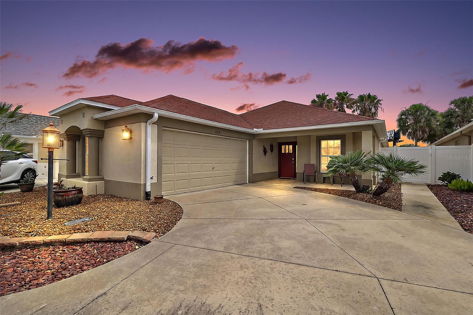 FABULOUS, PRIVATE 3/2 Arlington Courtyard Villa with 23’x24’ FULL TWO-CAR GARAGE, CLIMATE-CONTROLLED GLASS-ENCLOSED LANAI, EXPANSIVE REAR and SIDE PATIOS, and LOW-MAINTENANCE STONED LANDSCAPING in the highly sought-after Village of Haciendas of Mission Hills! JUST MINUTES to LAKE SUMTER LANDING with live nightly entertainment! BOND PAID! NEW HVAC! A CHARMING front porch  and CONTEMPORARY side-lit entry door welcomes you into the SPACIOUS foyer. Throughout the home, ELEGANT CROWN MOLDING and PLANTATION SHUTTERS adorn every room. The OPEN-CONCEPT living, dining, and kitchen areas are enhanced by SOARING VAULTED ceilings, creating a BRIGHT and EXPANSIVE gathering space while two sets of DOUBLE windows and sliding glass doors flood the home with NATURAL LIGHT. The STUNNING kitchen features RICH WOOD cabinetry, GRANITE countertops, GLASS TILE backsplash, STAINLESS appliances, and DOUBLE BUILT-IN PANTRY with ROLL-OUT shelving. The LARGE U-SHAPED CENTER ISLAND is beautifully accented with GLASS TILE and serves as both a functional workspace and casual dining area. From the living room, sliding glass doors open to a CLIMATE-CONTROLLED, GLASS-ENCLOSED lanai featuring a MINI-SPLIT, stone-patterned flooring, and solar shades. This INVITING space adds approximately 160 square feet of additional living area, making it ideal for year-round enjoyment. An exterior glass door leads to an EXPANSIVE OUTDOOR RETREAT, where a 40' x 16' rear patio seamlessly connects to a 72' x 8' side patio, creating multiple areas for relaxing, dining, and entertaining. Enclosed by a masonry wall and fencing, this courtyard-style setting offers EXCEPTIONAL PRIVACY and a peaceful, secluded atmosphere! Back inside, the primary bedroom boasts a TRAY ceiling, CUSTOM WALK-IN closet, and sliders to the lanai. Its en suite bathroom features WOOD cabinetry with GRANITE countertops, DUAL sinks, and TILED WALK-IN shower. Bedroom two offers a TRAY ceiling  and a CUSTOM built-in closet. The second bathroom features a WOOD vanity with GRANITE top, tub and shower combination, and a hall LINEN closet. The third bedroom boasts a VAULTED ceiling, EXTENDED double windows, and a CUSTOM built-in closet. Just off of the kitchen, behind a POCKET door, is an INTERIOR laundry room with WHITE cabinetry, PANTRY/STORAGE closet, hanging rod, and a utility sink. Completing the package is a 552sf TWO CAR GARAGE with a workbench, cabinetry, attic access with stairs, whole-house NOVA water filtration system, FROTEC water softening system, and PLENTY of space for parking and storage! DON’T MISS YOUR OPPORTUNITY to make this AMAZING HOME YOUR OWN! The quaint Village of Haciendas of Mission Hills is a small, picturesque neighborhood that sits on the water with its own pool, bocce and shuffleboard courts, horseshoe pit, and postal facility. It’s IDEALLY LOCATED with BEAUTIFUL Lake Sumter Landing JUST ACROSS the water! Close to Hacienda Hills, Tierra Del Sol, and Palmers Legends Championship Golf and Country Clubs; Mira Mesa, Silver Lake, De La Vista, and Chula Vista Executive Golf Courses; Laurel Manor, and La Hacienda Regional Recreation Centers; and Coconut Grove, Cordoba, Rio Grande, and Chula Vista Neighborhood Recreation Centers. This amazing community is located directly off of CR466 with an abundance of shopping, dining, medical, banking, and more right at your fingertips! PLEASE WATCH OUR WALKTHROUGH VIDEO of this INCREDIBLE HOME and call today to schedule your Private Showing or Virtual Tour!