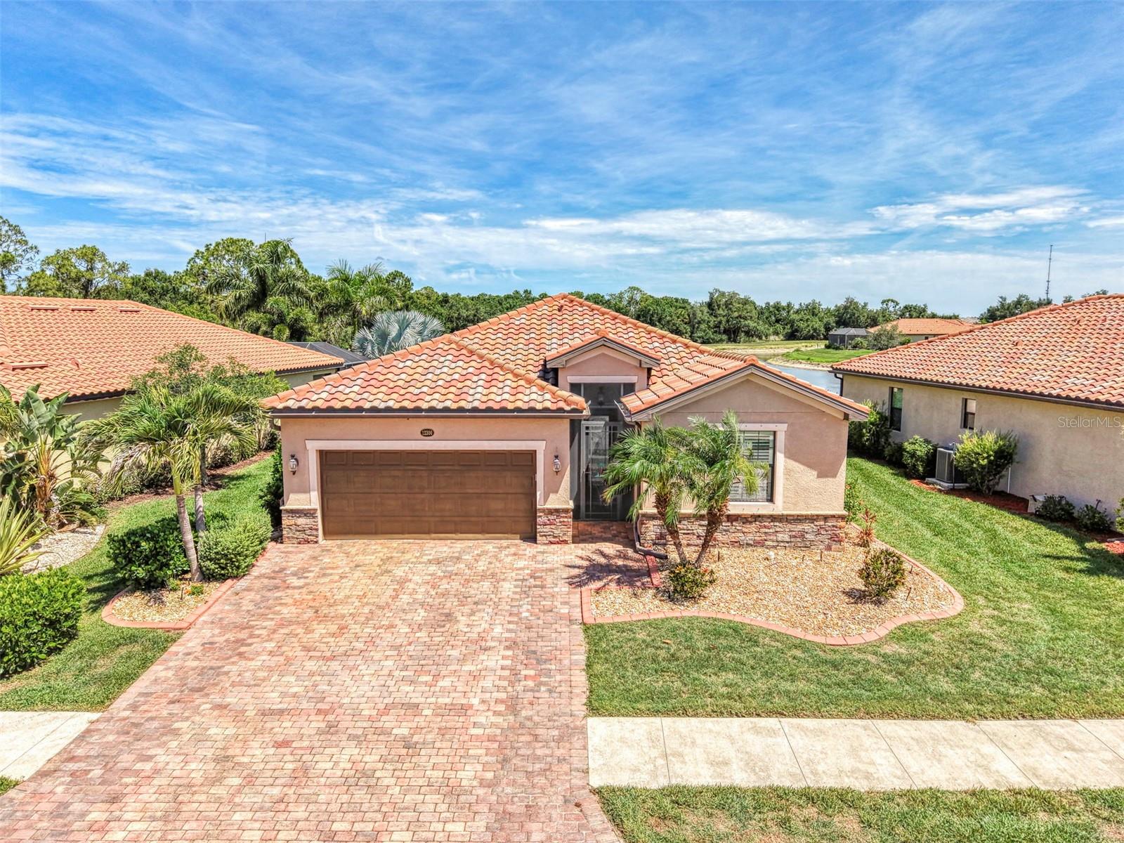 Virtually Staged. This beautifully upgraded 3-bedroom, 3-bath home plus study/den in Gran Paradiso offers peaceful and expansive water plus preserve views, delivering exceptional value rarely found in new construction. From the moment you arrive, the Mature Landscaping, Custom Curbing, Expanded Driveway and Screened Front Entry create an impressive welcome. Inside, the open floor plan with high ceilings, crown molding, and a true split-bedroom layout feels bright and spacious. Elegant Plantation Shutters throughout, 8-foot sliding glass doors, and a large Extended Lanai with Clear-View screening showcase the stunning water views. The Chef’s kitchen features ample cabinetry, tile backsplash, soft-close cabinet doors and a large Walk-In Pantry with a stylish door, while the dining area and den/study showcase beautiful shiplap accent walls. Both the Primary Bedroom and one Guest Bedroom are En Suite, while the additional Guest Bedroom offers complete privacy with its own adjacent bathroom. The Primary En Suite features dual sinks, a soaking tub, separate shower, and private water closet. Additional upgrades include a Water Softener, kevlar Hurricane Screens on the covered lanai, and a Fenced Enclosure off of the lanai, adding valuable outdoor functionality. The CDD Bonds have been PAID in FULL, delivering significant SAVINGS of over $1100/ year to the Buyer. Best of all, this home comes with fully OWNED Tesla Solar Panels— providing a very low monthly electric bill and annual credit from energy returned to the grid. Why rely on a generator when this home already includes a Tesla Solar System Battery Backup? Gran Paradiso offers resort-style amenities including a pool, fitness center, tennis, pickleball and walking trails. You’ll love being just minutes from Downtown Wellen Park’s restaurants, shopping, the Atlanta Braves Spring Training Center, and the pristine Gulf beaches. This is the one — an exceptionally upgraded home with water views, major cost-saving features, and move-in-ready appeal. Schedule your private showing today and experience why this home stands out from the rest.