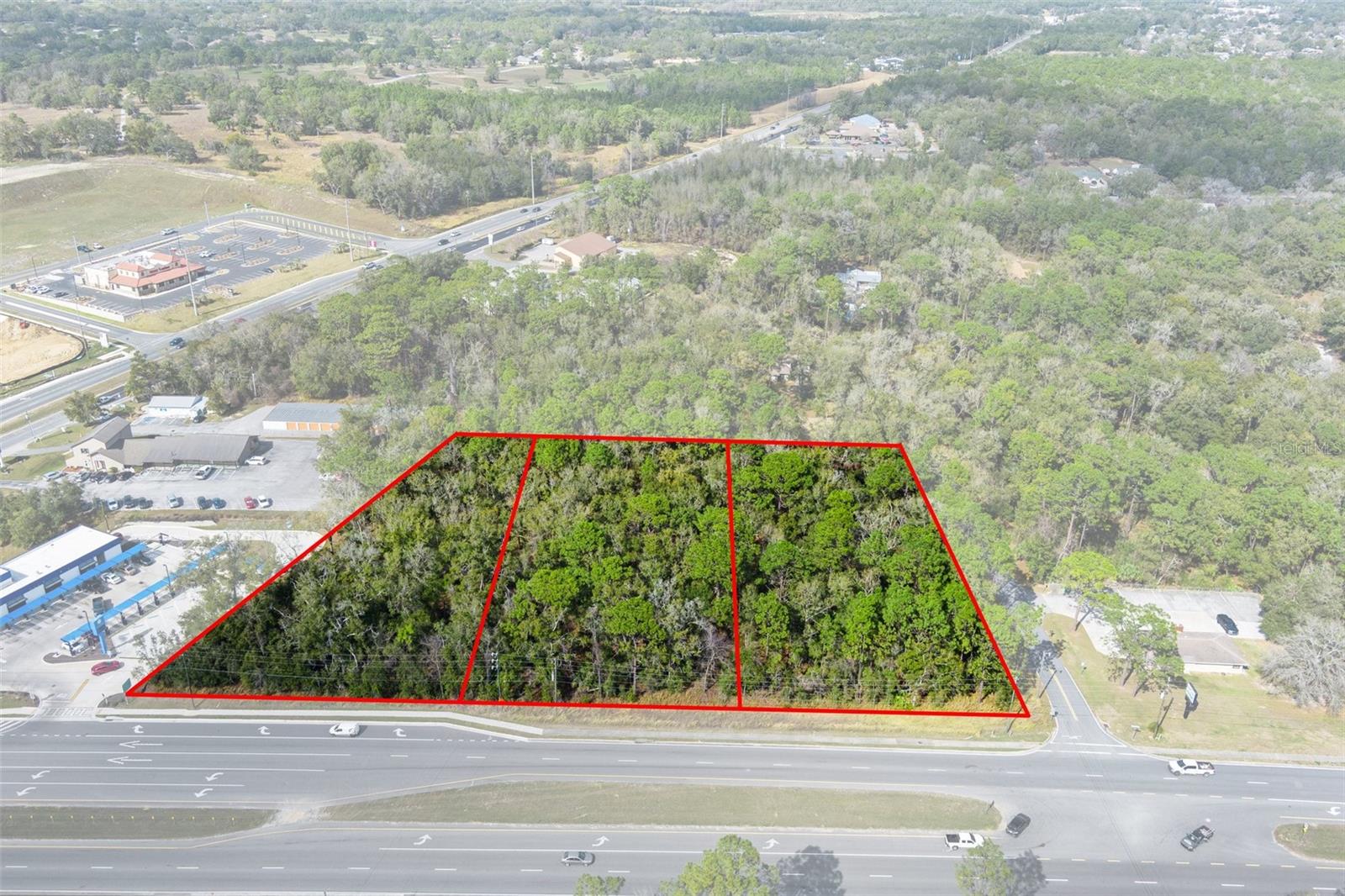 This prime multi-parcel land development opportunity is located in the Central Ridge District of Citrus County, Florida, strategically positioned within the region’s largest national retail hub expansion. Surrounded by major retailers such as Target, ALDI, Walmart, McDonald’s, Panda Express, Texas Roadhouse, Panera, and Starbucks, the site benefits from strong retail synergy and high consumer traffic, making it an attractive investment for commercial developers. The property consists of three parcels totaling 3.57 acres: Lot 19 (1.24 acres, 150’ x 350’ corner lot), Lot 20 (1.24 acres, 150’ x 350’), and Lot 21 (1.09 acres, 215’ x 350’). It has direct access to county utilities, including sewer, and is zoned under the PSO Commercial district (Citrus County Ch. 2 LDC), allowing for 70% lot coverage and a variety of permitted uses such as professional and medical offices, emergency rooms, regional hospitals, retail, dine-in and drive-thru restaurants, hospitality, pharmacies, medical marijuana treatment centers, assisted living facilities, and multifamily developments of up to 10 units per acre. Located at the northwest corner of CR 486/W Norvell Bryant Hwy and N Crookedbranch Drive, the property offers over 510 feet of prime frontage with full ingress and egress via a median cut, ensuring seamless traffic flow and high visibility. Disclaimer: All information provided herein is for marketing purposes only and is not guaranteed for accuracy. Prospective buyers or tenants are encouraged to conduct their own independent due diligence. The seller, broker, and associated parties make no representations or warranties, expressed or implied, as to the accuracy or completeness of this information. All dimensions, zoning details, financial data, and other property-related facts should be independently verified. Please consult with appropriate licensed professionals before making any investment or purchasing decisions.