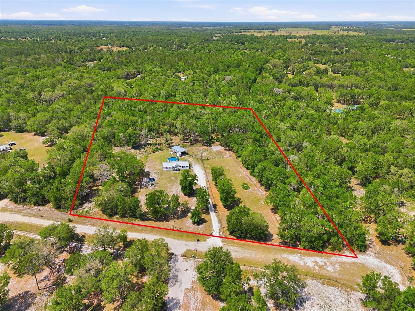 PRICE IMPROVEMENT!! These sellers are motivated! This is a rare opportunity to own a fully renovated home on 10 fenced acres in Fort White, just 5 miles from the Ichetucknee River and conveniently located close to Lake City, High Springs, and Gainesville. This move-in ready 3-bedroom, 3-bathroom property blends modern upgrades with functional country living.
Inside, the open-concept layout features updated finishes throughout, including a stylish kitchen with quartz countertops, two-tone cabinetry, stainless steel appliances, and a walk-in pantry. The living area is anchored by a sleek electric fireplace, while a dedicated laundry/mudroom adds everyday convenience and storage.
The primary suite offers a unique his-and-hers bathroom setup, one with a freestanding soaking tub and the other with a walk-in shower, along with spacious walk-in closets.
Outdoors, the property is thoughtfully set up for both relaxation and use, featuring multiple fenced areas ideal for animals, a 24x48 pole barn with two horse stalls and a wash rack, and an above-ground pool with a surrounding deck, perfect for enjoying the peaceful setting with summer right around the corner. Both front and rear decks provide additional space to unwind or entertain.
Major updates include a metal roof (2018), HVAC (2016), and water heater (2024). No HOA or deed restrictions, offering the flexibility to live, work, and enjoy your land your way!