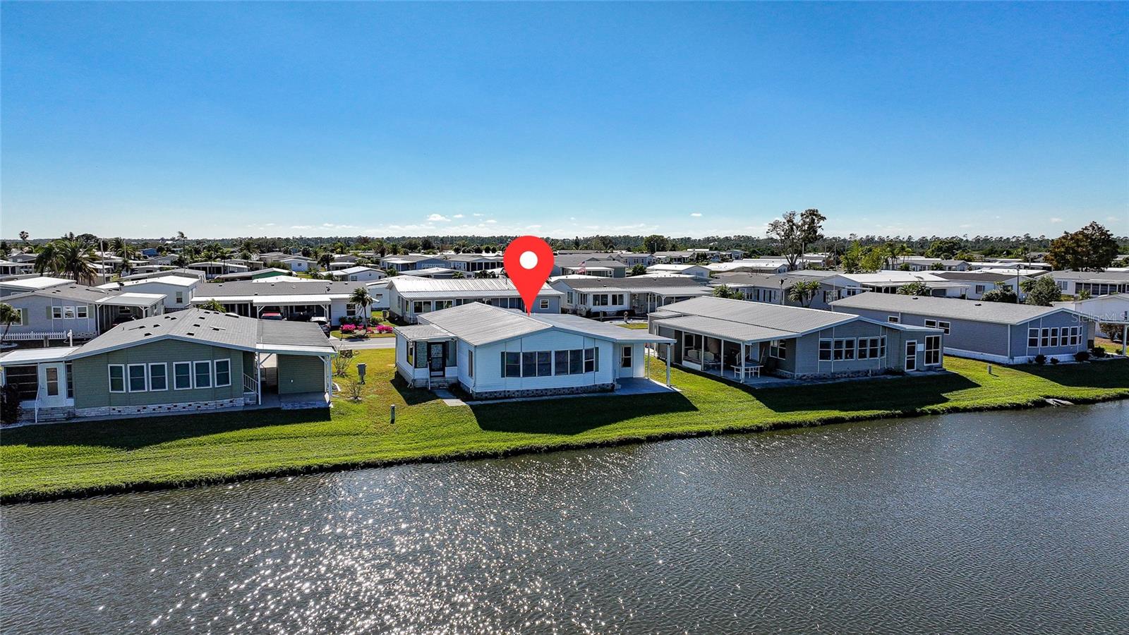 Lowest-priced waterfront property on the market. Seller states the home is valued at approximately $200,000; priced below market value to account for the property’s current condition and the existing Building Enforcement violation for the construction of a wood-framed carport and shed without permits. Updated, modern home, perfectly situated on Lake Dolphin in the premier 55+ gated community of Harbor Isles. Land owned. BRAND NEW VAPOR BARRIER. Seller states home has a newer metal roof, a carport, and a shed. 2022 A/C. This home offers unobstructed, panoramic views of Lake Dolphin and is just 0.1 miles from the community boat ramp and kayak launch. The modern kitchen opens to a spacious living area ideal for entertaining, featuring an oversized island, new stainless steel appliances, a wall oven, and cooktop. The primary bedroom offers an ensuite updated bathroom and two walk-in closets, while the guest bedroom includes its own ensuite bathroom and walk-in closet, providing comfort and privacy for residents and guests. Spacious, long, and wide carport with plenty of parking, complemented by an oversized shed featuring a conveniently located washer and dryer. Harbor Isles is a premier, gated 55+ community situated along the scenic Myakka River, just minutes from the Gulf of America. LOW HOA $196 a month. NO LOT Rent. Residents enjoy an impressive array of amenities, including a heated pool and spa, state-of-the-art fitness center, tennis and pickleball courts, bocce and shuffleboard, an expansive clubhouse, library, and a marina offering boat and kayak access to the Gulf. This pet-friendly community features a vibrant social calendar with clubs and activities for every interest, making Harbor Isles the perfect place to enjoy an active and relaxed Florida lifestyle. There is plenty of wildlife to enjoy; herons, egrets, cranes, ibis, parrots, even alligators and manatees! Conveniently located within minutes of Downtown Wellen Park, Costco, shopping, restaurants, and a short drive to beautiful Gulf Beaches. Schedule a viewing today and make this dream home a reality!