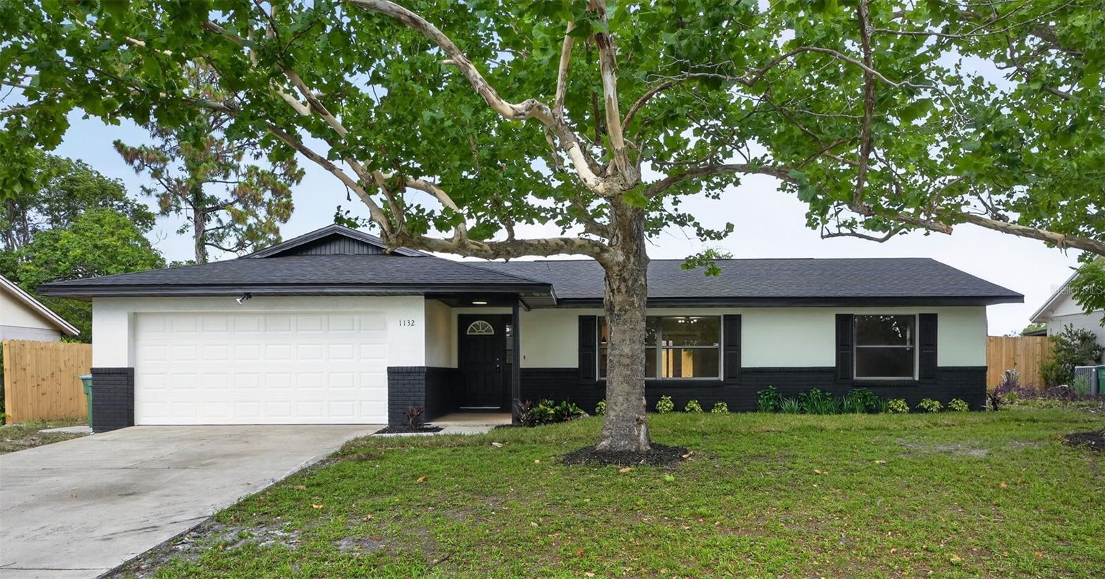 Virtually Staged. Welcome home to this meticulously remodeled 3-bedroom, 2-bath block home in Deltona, Florida! No detail was overlooked in this top-to-bottom transformation, from the brand new roof, AC system, and hot water heater to all new appliances, luxury flooring, and updated fixtures throughout. Offering 1,489 square feet of beautifully designed living space, the open-concept kitchen and dining area shine with white shaker cabinets, quartz countertops, a large center island with ample storage below, and stainless steel appliances, all flowing seamlessly into the living space. Spacious bedrooms feature stylish ceiling fans and luxury vinyl plank flooring, while the primary suite offers a comfortable and private feel in a split floor plan layout. A versatile bonus area provides the perfect opportunity to create a home office or flex space to fit your needs. Step outside to your brand new fully fenced backyard – plenty of room to add a pool and create your own Florida oasis. The covered front porch and freshly landscaped exterior give this home incredible curb appeal with its bold, modern black and white finish. Two-car garage, 80 x 125 lot (approx. 0.22 acres), and located in a convenient Deltona neighborhood close to shopping, dining, and major highways. This is truly move-in ready – just unpack and enjoy the Florida lifestyle! Some photos have been virtually staged.
