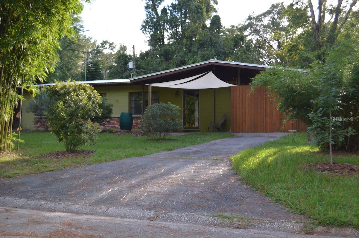 Eastside Gem: Mid-Century Modern 3 bedroom 1 bath concrete block home with beautifully landscaped yard, lots of natives like wax myrtle, coontie, green ash, simpson's stopper, as well as olive trees, loquat, guava, garden with cherry tomatoes, turmeric, kale, 3 varieties of clumping bamboo including large timber bamboo and the micro multiplex bamboo. New metal roof was installed in 2018. Upgrades to interior including fresh paint on all walls, new door hardware, insulation added to attic, new fridge 2018, new dishwasher 2018, gas range and oven 2015, microwave above gas stove with proper vent to outside, hot water heater and washer/dryer 2015, HVAC has not been replaced but has been serviced and works great, ducts cleaned and sealed.  Floor in the main living space is a unique epoxy application using re-purposed brown paper bags, epoxied down and painted brown before sealing with polyurethane- makes for a very durable and pleasant floor. 15 minute walk to Satchel's, Re-Purpose Project, not far from Eastside Eatery, 10 minute walk to Smokey Bear Park with awesome playground, large trees, and fruit orchard.  Play structure in the backyard has a 50W Solar panel on the roof and charges a small battery for kids to play with lights or other electronics. Large 8' tall privacy fence along the backside of property and front sides of the house, creates a very private and secure backyard, great for dogs and kids. Smaller fenced area extends from the back of the house behind the utility room which has a doggie door so that a dog can stay in the utility room and have access to outside. Large walk-in pantry extends off of the side of the kitchen.