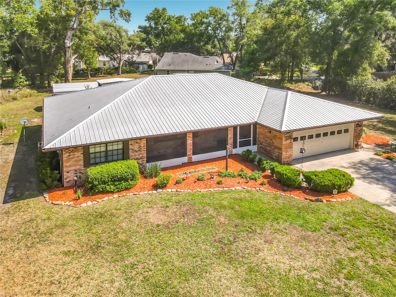 Welcome to your perfect home in small golf cart community with NO HOA and private beach and lake access! This solid 3/2 brick home on oversized lot allows you the FREEDOM to truly make this property your own! Enjoy piece of mind with a whole house generator, two newer A/C units with HALO air cleaner, metal roof, spray foam insulation, sec cameras, alarm, multi zone sprinkler system and gutters. Homes interior is nicely updated with newer flooring, fresh paint, granite countertops, new refrigerator, newer water heater and new washer & dryer. Nice floor plan with split bedrooms, seperate living room and dining room, wood burning fireplace in family room and even a dinette area off kitchen. Entertain or just relax on two beautiful covered porches, one in the front and a spacious enclosed porch on the back overlooking your future garden area, large walk in shed with electric and a seperate one car carport for tractor, toys or extra vehicle. Deeded lake access to S Twin Lake along with private beach area that is just around the corner-perfect for fishing, boating, kayaking or simply unwinding lakeside. Great school district and close to Ocala Forest, Alexander Springs and more. If you're looking for durability, efficiency in your next Florida home, this is it!