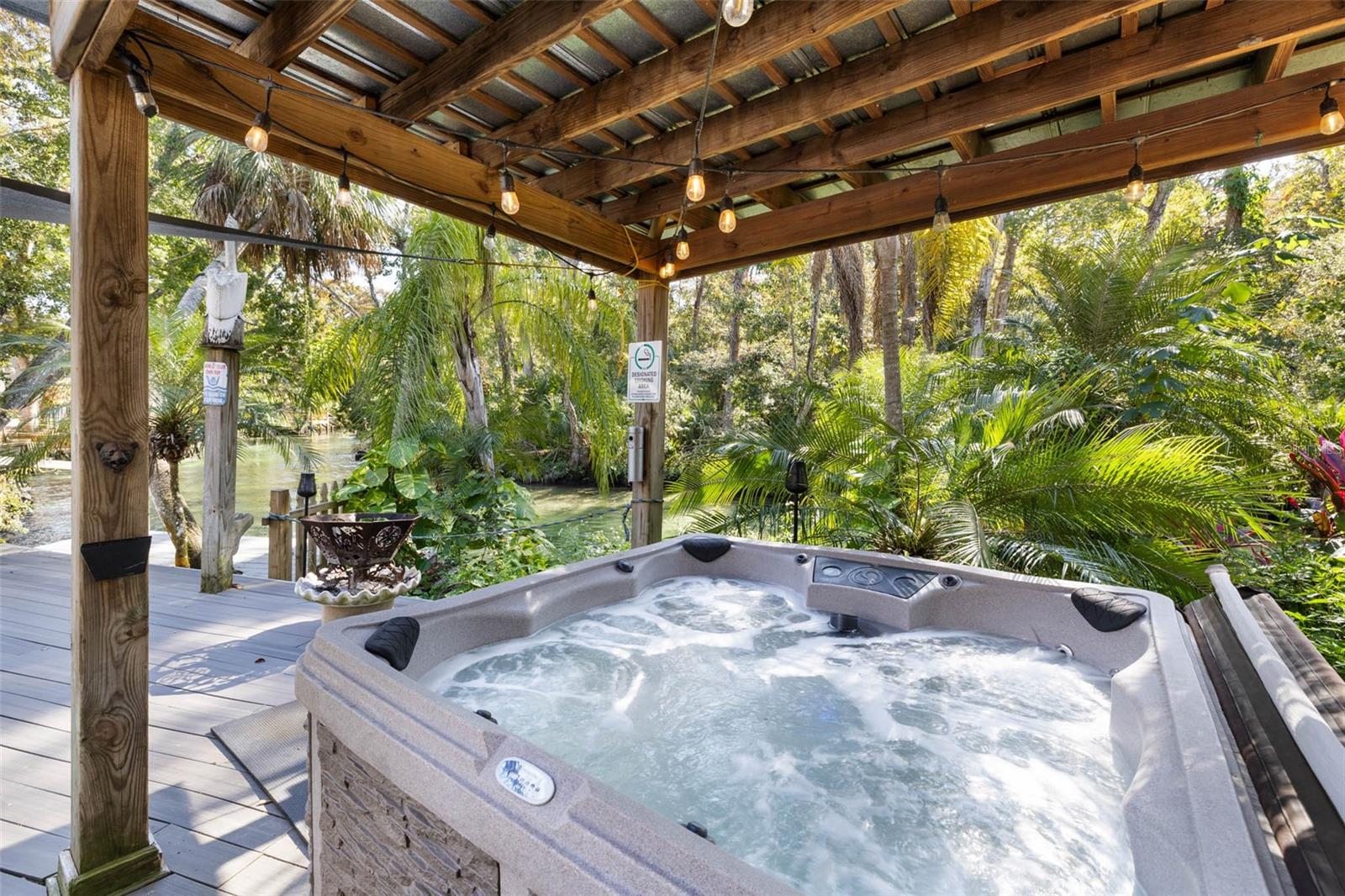SOLD TURNKEY | ACTIVE VACATION RENTAL | $90K+ 2025 INCOME — ONE-OF-A-KIND WATERFRONT PARADISE ON THE MAIN Weeki Wachee River
Live like you’re on vacation every day on the AMAZING, CRYSTAL-CLEAR WEEKI WACHEE RIVER, with access right from your backyard. Swim, kayak, and paddle alongside manatees while enjoying protected no-build views across the river that provide lasting privacy and an unspoiled natural backdrop.
Designed for both relaxation and entertaining, the outdoor space features expansive TREX DECKING, a private KAYAK LAUNCH  with wet deck, mature oak trees, sunshades, and a pergola for all-day comfort. A FIRE PIT, HOT TUB and fully equipped OUTDOOR KITCHEN create the perfect setting for year-round enjoyment, while a she-shed adds additional storage and the fully FENCED YARD  enhances privacy. Included with the property are kayaks, paddleboards, and a john boat, making it truly move-in and rental ready.
Just off the backyard is a spacious SCREENED IN PORCH complete with a TV and ceiling fan, flowing seamlessly into a large living area with an oversized couch, arcade space, and library. The open-concept kitchen overlooks the river and is appointed with QUARTZ countertops, two-tone cabinetry, subway tile backsplash, a 36-inch glass cooktop with stainless hood, built-in oven and microwave, and a recessed refrigerator. The dining area features cathedral ceilings and a striking spiral staircase that adds architectural character.
Two well-appointed guest bedrooms on the main level offer tongue-and-groove ceilings, queen-sized beds, futons, and ample storage, with one bedroom providing direct access to the backyard. The shared bathroom includes a walk-in glass shower with a floor-to-ceiling tile accent wall.
The second level serves as a PRIVATE PRIMARY RETREAT, accessible via the inside spiral staircase or rear exterior entry. The suite features an ensuite bath with a tub/shower combination and marble-top vanity, along with French doors that open to a 14x23 SCREENED IN PORCH  overlooking the river. This elevated outdoor screened in space is ideal for relaxing or entertaining, complete with seating, games, and a gas fire pit.Additional features include a durable METAL ROOF, custom front door, PLANTATION SHUTTERS, vinyl siding on the front, Hardie board siding on the rear, and ample parking. Transferable flood insurance ($4,702/ year) and reasonable homeowners insurance ($2219/ year) provide added peace of mind. 
Currently operating as a successful active vacation rental, future bookings can convey to the new owner, offering immediate income potential. Just minutes from the world-famous Weeki Wachee Springs State Park. Residents enjoy close proximity to shopping, dining, hospitals, and top-rated schools. The community allows short-term rentals with no HOA and no deed restrictions, making it perfect for full-time residents, part-time snowbirds, or investors. The nearby Suncoast Parkway provides easy commuting to Tampa, Brooksville, and surrounding areas. This one-of-a-kind riverfront property offers incredible views, exceptional outdoor living spaces, and endless opportunities for boating, entertaining, and relaxing in your own private paradise.