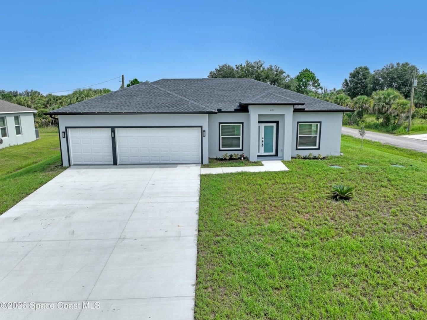 Welcome to this beautifully crafted, brand-new single-story home on a 0.27-acre CORNER LOT. With 4 spacious bedrooms and 2 full baths 3CAR GARAGE!, this home is perfect for the growing family or those looking to retire in comfort. Full 3-car garage - a rarity in new construction at this price point. High-end finishes: vinyl plank flooring, tiled showers, all white plywood cabinetry, and a stylish kitchen backsplash. Impact-rated windows and doors provide peace of mind and durability. 10-foot ceilings elevate the open-concept interior space, creating a light and airy feel. Split-bedroom design with an open floor plan gives privacy and flow for everyday living as well as entertaining. Garage floor has epoxy!! Excellent location just minutes away from the Bayside Lakes area, key amenities including a supermarket (Publix), high school and more. 1year builder warranty and septic tank is in the front leaving you room for a POOL!