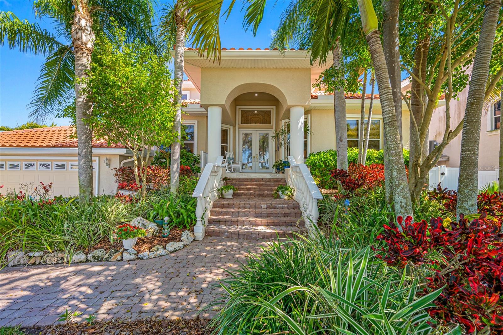 Nestled in the heart of the Island Estates boating community, this exquisite home was custom built in 2001 and features spacious living areas with an expansive lanai overlooking the pool, spa, and stunning waterfront views.  Designed to surpass FEMA's Base Flood Elevation minimums, this home boasts quality construction and meticulous upkeep, ensuring an unrivaled standard of living. For boating enthusiasts, there is a 30-foot dock and boathouse with 10K lb lift capacity and easy access to the Intracoastal Waterway and Clearwater Pass. The floor plan includes a spacious entry foyer with formal dining area and large living room with soaring 21-ft ceilings, complemented by an alcove wet bar area and 1,000-bottle wine storage room.  Natural light infuses this area creating an environment for lively gatherings or tranquil moments of solitude.  The generously sized kitchen has custom cabinetry, granite countertops, central island and breakfast bar, and is open to both the large breakfast room and the adjoining family room, all with views of the water.  Additional first floor amenities include an en-suite bedroom, laundry room, powder room, butler's pantry, and a versatile artist's niche, perfect for use  as an office, game room or reading nook.  There is large format Italian porcelain tile throughout the main level which unifies the space and adds to the feeling of expansiveness.  On the second floor the primary bedroom suite awaits, featuring a large sitting area, a balcony offering captivating water views, expansive his-and-hers walk-in closets, and a luxurious bath complete with dual sinks, walk-in shower, corner tub and private water closet.  Accompanying this retreat are a third bedroom with a Jack and Jill bath, and an adjacent fourth bedroom currently serving as an office. Key features include a 25kw whole house GenerX generator, new tile roof in 2019, Blue Stone quartz resurfacing of the pool and spa in 2023, the addition of custom fence and railings surrounding the pool and lanai in 2022, replacement of the upstairs zone HVAC in 2023, exterior painting in 2020, replacement of wine storage room cooling system in 2021, new Rinnai gas-fired tankless water heater in 2023, and whole house upgrade of television/sound/internet systems in 2023/2024.  Whether indulging in water sports, bicycling along the Pinellas Trail, or savoring breath-taking sunsets, this coveted Island Estates waterfront location caters to myriad lifestyles.  More than just a home, this property represents an investment in a lifestyle characterized by tranquility, luxury, and convenience.
