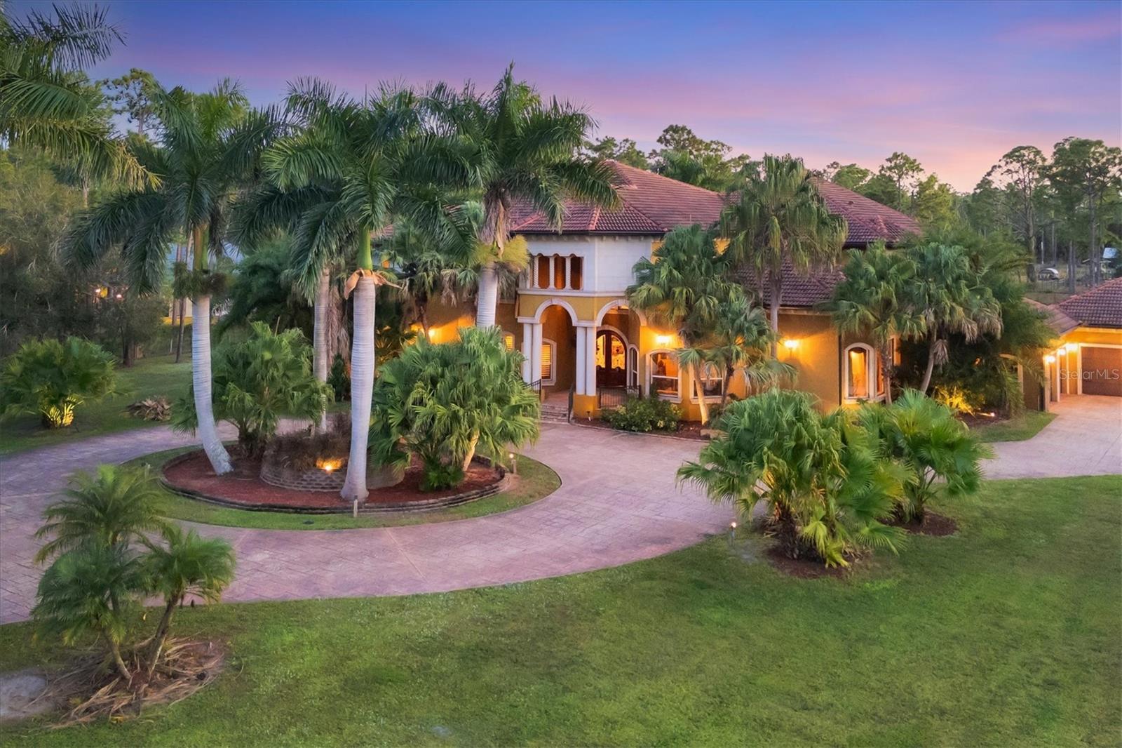 Welcome to this spectacular custom-built estate, a private luxury retreat set on 3 gated and fully fenced acres with a palm-tree-lined driveway that sets the tone for the grandeur within. Designed with uncompromising quality, state-of-the-art systems, and extraordinary architectural detail, this residence offers the perfect blend of elegance, comfort, and modern innovation—truly one of the area’s finest estate properties. You’ll be instantly awed upon opening the imported arched double-entry doors, revealing a dramatic grand staircase, intricate custom mosaic inlays, and gleaming marble flooring throughout. Exquisite millwork and soaring ceilings elevate every space, including arched, coffered, vaulted, and a striking barrel-vaulted ceiling in the formal dining room. The formal living room is as magnificent with its soaring masterfully-detailed ceiling highlighted by an impressive full glass window wall. This 8,541 sq ft masterpiece features 6 bedrooms and 6.5 bathrooms, with thoughtful multigenerational design offering two first-floor guest suites, each with its own en suite bath and walk-in closet. Every bedroom throughout the home is a private retreat with its own en suite bathroom and walk-in closet. The gourmet chef’s kitchen is the heart of the home, boasting high-end finishes, gas appliances, extensive cabinetry, and seamless flow into the living areas. A sweeping second-floor balcony extends both indoors and outdoors, creating dramatic architectural presence and multiple elevated vantage points. The luxurious primary suite includes a serene sitting area, dual walk-in closets, a sculptural free-standing soaking tub, separate vanities, and a massive walk-through spa shower. Additional interior amenities include a state-of-the-art theater, dedicated fitness room, an upstairs family and billiards room, a hurricane/tornado safe room, advanced home automation, central vacuum, and a whole-house audio and intercom system. The resort-style outdoor living space is designed for grand-scale en tertaining with a heated saltwater pool, jacuzzi, spa, and fully equipped outdoor kitchen. This estate is engineered for ultimate comfort, performance, and peace of mind with a whole-house reverse osmosis water treatment system, gas appliances, gas fireplace, two gas instant hot water heaters, a 1,000-gallon gas tank, and whole-home gas generators capable of powering the entire property. Additional upgrades include hurricane-impact windows and five independent air-conditioned zones. A truly exceptional estate offering privacy, security, world-class construction, and unmatched luxury.