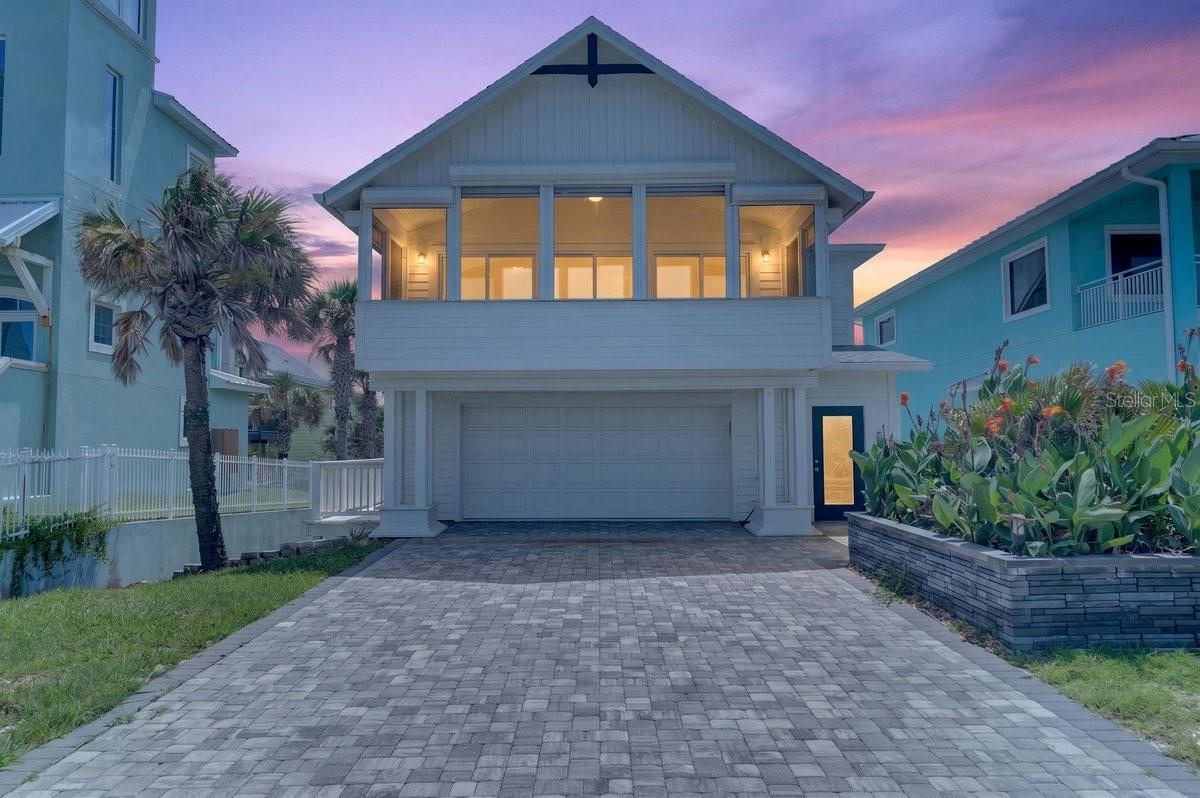 Experience the ultimate in oceanfront living with this beautifully renovated 4-bedroom, 4-bath coastal retreat in the highly sought-after Bethune Beach community of New Smyrna Beach. Perfectly positioned on a pristine no-drive beach with its own private dune and beach walkover, this exceptional residence offers the rare combination of tranquility, privacy, and direct access to the sand and surf. Designed for both luxury and functionality, the two-story home features four spacious bedroom suites—each with its own private bath—including two upstairs suites with private balconies overlooking the Intracoastal Waterway and spectacular sunset views, and two downstairs suites with private covered porches and separate exterior access for added convenience and flexibility. A rare 462-square-foot basement provides valuable storage seldom found in oceanfront homes, while the oversized two-car garage with epoxy floors offers abundant space for vehicles, bicycles, surfboards, beach chairs, fishing gear, and all your coastal toys. A welcoming foyer leads upstairs to the main living level where soaring vaulted ceilings with exposed wood beams, wide-plank hardwood flooring, white shiplap walls, and view-capturing windows create a bright, sophisticated coastal atmosphere. The open-concept living, dining, and kitchen areas are perfectly oriented to capture breathtaking panoramic Atlantic Ocean views and flow seamlessly through sliding glass doors to a spacious covered oceanfront balcony where you can relax to the sound of the waves and refreshing sea breeze. The designer kitchen impresses with white countertops, rich dark cabinetry, a whitewashed brick backsplash, and premium stainless steel appliances including a gas range, wall oven, built-in microwave, dishwasher, and refrigerator. Luxurious bathrooms showcase large-format marble-look tile, matte black fixtures, and contemporary lighting, while the serene bedroom suites continue the home's elegant coastal aesthetic with plank ceilings, recessed lighting, and a custom walk-in closet in the primary suite. Abundant windows throughout fill the home with natural light, enhancing the inviting interior. Just minutes from boat ramps accessing the Indian River Lagoon, the restaurants, boutiques, and entertainment of Flagler Avenue, and the charm of historic Canal Street, this extraordinary property is equally suited as a primary residence, luxury vacation home, or income-producing investment. With very few direct oceanfront homes available—and even fewer vacant oceanfront lots remaining to build—this is a rare opportunity to own an irreplaceable piece of New Smyrna Beach's spectacular coastline. ALL INFORMATION IS ASSUMED ACCURATE BUT NOT GUARANTEED. ALL MEASUREMENTS ARE APPROXIMATE. BUYERS AND THEIR AGENTS SHALL VERIFY ANY INFORMATION DEEMED IMPORTANT TO THEM.