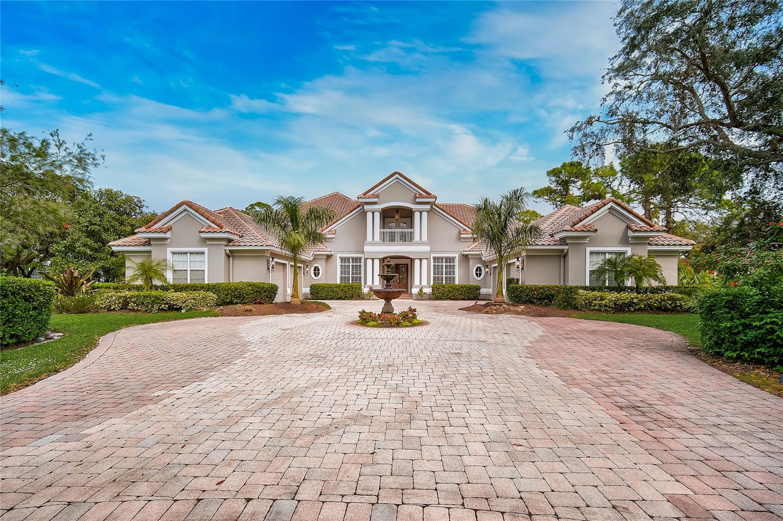 One or more photo(s) has been virtually staged. Set on a private cul-de-sac within The Oaks, this revitalized estate captures the essence of elegant Florida living. From the moment you enter, the home’s light-filled, open design and thoughtful updates make an immediate impression. The main living spaces flow effortlessly from the chef’s kitchen to expansive entertaining areas and out to the lanai, where golf course views frame the heated pool, spa, and outdoor kitchen.

The first-floor primary suite is a true retreat, featuring high ceilings, multiple closets, and a flexible sitting area that can serve as a nursery, gym, or private office. Upstairs, guests enjoy their own wing complete with a loft, theater, and screened terrace—ideal for relaxing or hosting in style.

A split four-car garage, custom finishes, and generous room throughout reflect the craftsmanship expected in one of Sarasota’s most distinguished country club communities. The Oaks offers 24-hour security, two championship golf courses, an acclaimed racquets program, fitness and wellness facilities, and fine dining—all just minutes from the beaches and top-rated schools.

Experience this home for yourself—take the 3D virtual tour and book your private showing today.