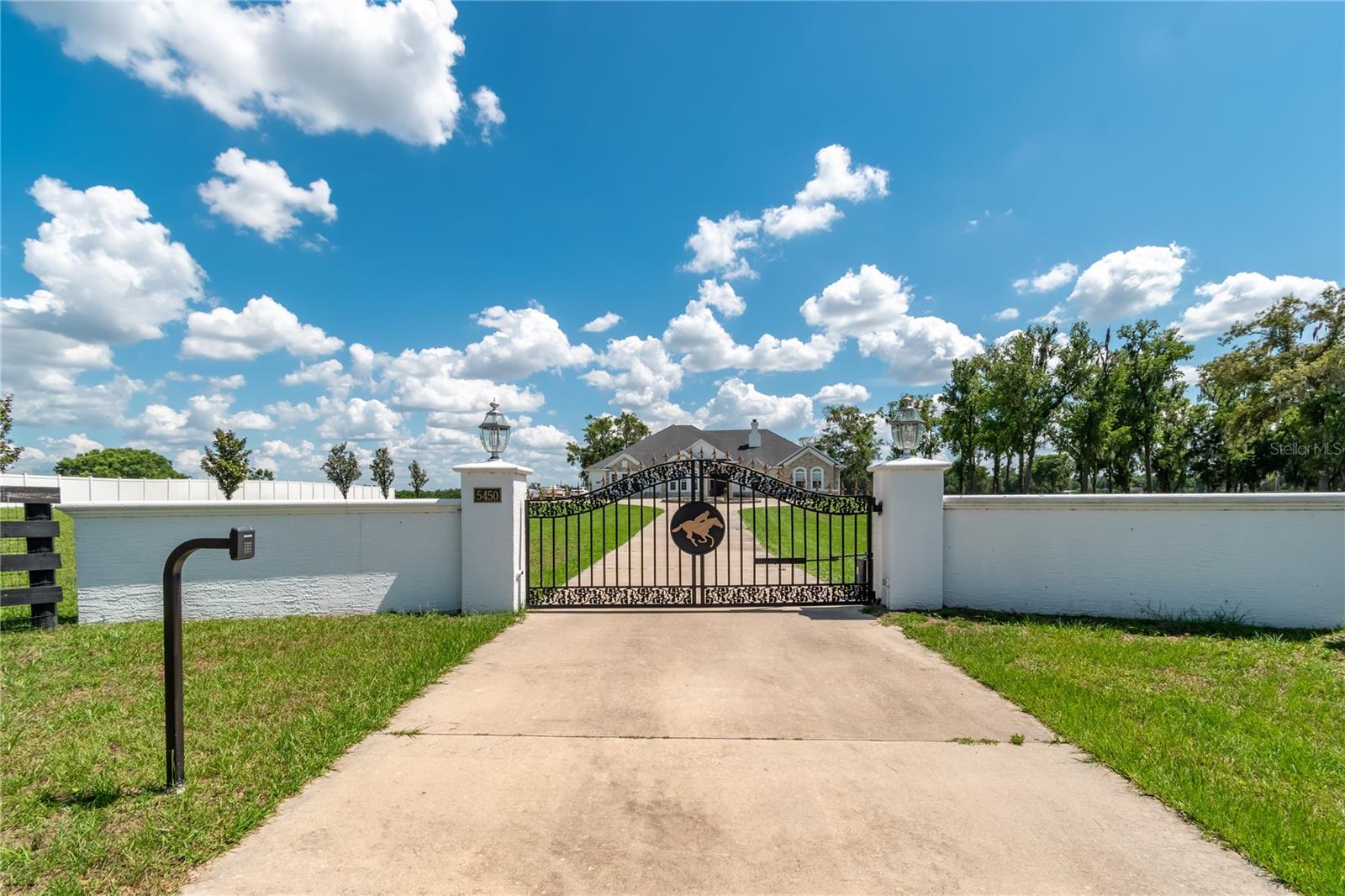 Under contract-accepting backup offers. Set on 80-acre in the heart of NW Marion County’s storied horse country, this thoughtfully designed training facility estate offers a rare combination of scale, function, and convenience less than 11 miles from both Ocala Breeders Sales and the Ocala International Airport. A true training center designed for serious horse operations, the property features four barns with an impressive combined 104 stalls, a Eurocizer, round pens, and expansive paddocks and pastures. A 3/4 mile irrigated training track with viewing stand and starting gate is a center-point for the property, offering year-round training with a size that is highly desirable and rarely seen in this area.The custom main residence offers over 3,700 square feet of living space with 4-bedrooms and 3-bathrooms in a thoughtfully designed split-bedroom floor plan. Interior features include soaring and tray ceilings, a double-sided wood-burning stone fireplace, spacious formal and casual living areas, large windows that fill the home with natural light and stunning views of the surrounding farm. A well-appointed kitchen is ideal for those who enjoy cooking, complete with custom cabinetry, granite countertops, stainless steel appliances, cooktop, walk-in pantry, and raised bar seating. The generous primary suite is nicely private, with an inviting en-suite with dual vanities, a soaking tub, separate shower, and large walk-in closet. Additional bedrooms provide flexibility for family, guests, or office space as desired. Equestrian improvements have been carefully designed to support a professional training or breeding operation. Three renovated concrete block shed-row barns each offer 32 stalls with tack rooms, offices, bathrooms, LED lighting, fly spray systems, feed rooms, and wash racks, while the charming 8-stall wooden pony barn adds versatility. Additional infrastructure includes multiple wells and septics, shavings pits, equipment storage, workshop space, feeding stations, and extensive board fencing throughout the farm. A remodeled guest/staff residence with two separate apartments provides comfortable accommodation options for employees or visitors, further enhancing the property’s functionality. Mature landscaping, lush green pastures with gentle roll, paved road access, and the farm’s prime location in Ocala’s renowned horse country make this an exciting opportunity for someone looking to bring their operation to the next level.
