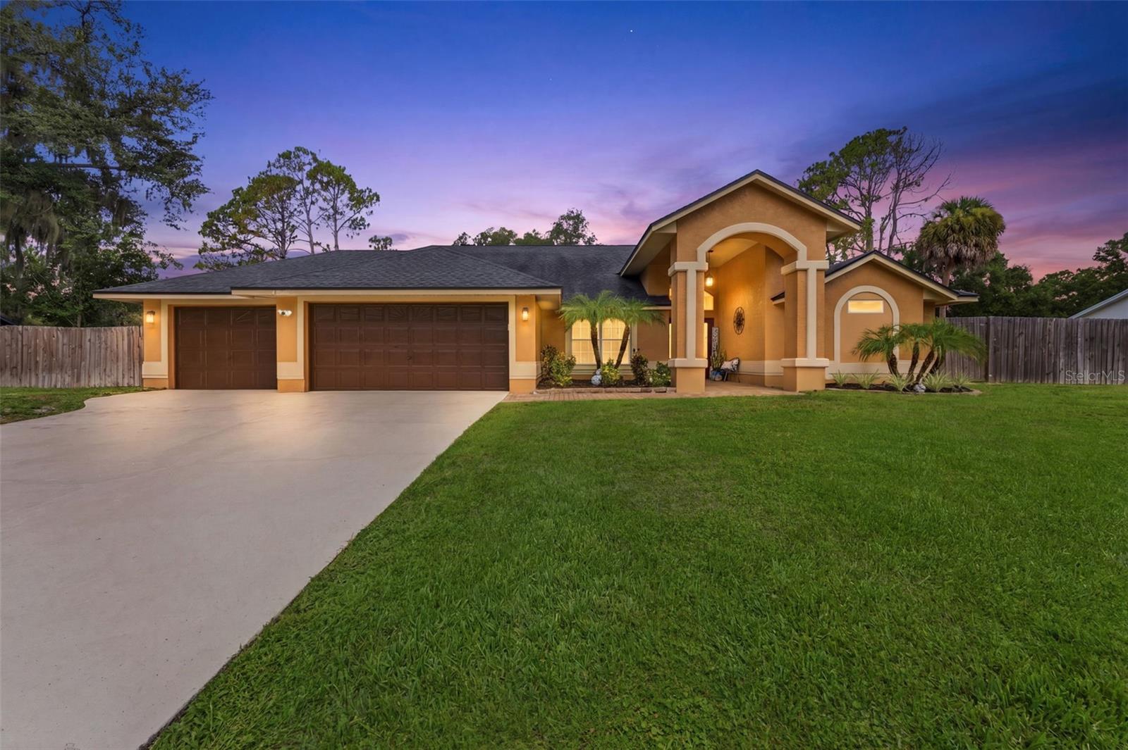 Set on a fully fenced half-acre homesite in highly desirable Lutz, this striking pool residence delivers an exceptional combination of elevated design, generous living space, privacy, and future potential. A sweeping driveway, oversized three-car garage, dramatic arched entry, and double front doors create an impressive arrival.

Inside, the four-bedroom, three bath floor plan is filled with architectural interest, including soaring ceilings, arched details, abundant natural light, a formal foyer, and beautifully defined living and dining spaces. Neutral finishes, updated flooring, modern chandeliers, recessed lighting, and thoughtfully selected fixtures create a polished atmosphere throughout.

The updated kitchen serves as the centerpiece of the home, featuring quartz countertops, gray cabinetry with contemporary hardware, a decorative mosaic backsplash, stainless steel appliances, under-cabinet lighting, a spacious center island, and an extended breakfast bar with seating. A built-in workstation and beverage area add both style and functionality, while the adjoining eat-in kitchen overlooks the pool and provides direct access to the screened outdoor living area.

The spacious family room is designed for relaxing and entertaining, highlighted by a dramatic floor-to-ceiling marble-look feature wall, electric fireplace, recessed display niches, ceiling speakers, and sliding glass doors connecting the interior to the lanai and pool. The home also offers a formal living room, formal dining room, dedicated laundry room, and an oversized three-car garage with abundant space for vehicles, storage, hobbies, or recreational equipment.

Outside, the expansive screened porch and pool create a private retreat for year-round Florida living. Beyond the pool enclosure, the fully fenced yard provides exceptional space and includes a professionally installed chicken coop and run, which will remain with the property. Numerous fruit-producing trees—including lemon, apple, plum, and peach—enhance the backyard setting.

Adding even more value and flexibility, the property includes approved site plans for an approximately 1,000-square-foot mother-in-law suite, offering an exciting opportunity for multigenerational living, guest accommodations, or additional private space. The approved plans will be included with the sale.

Located within the sought-after McKitrick Elementary, Martinez Middle, and Steinbrenner High school corridor, this distinctive Lutz property offers the space, upgrades, outdoor lifestyle, and expansion potential that are increasingly difficult to find.

**Washer, dryer, and refrigerators located in the garage do not convey. Buyer to verify school assignments, site-plan approvals, permitting requirements, dimensions, and all property information.**