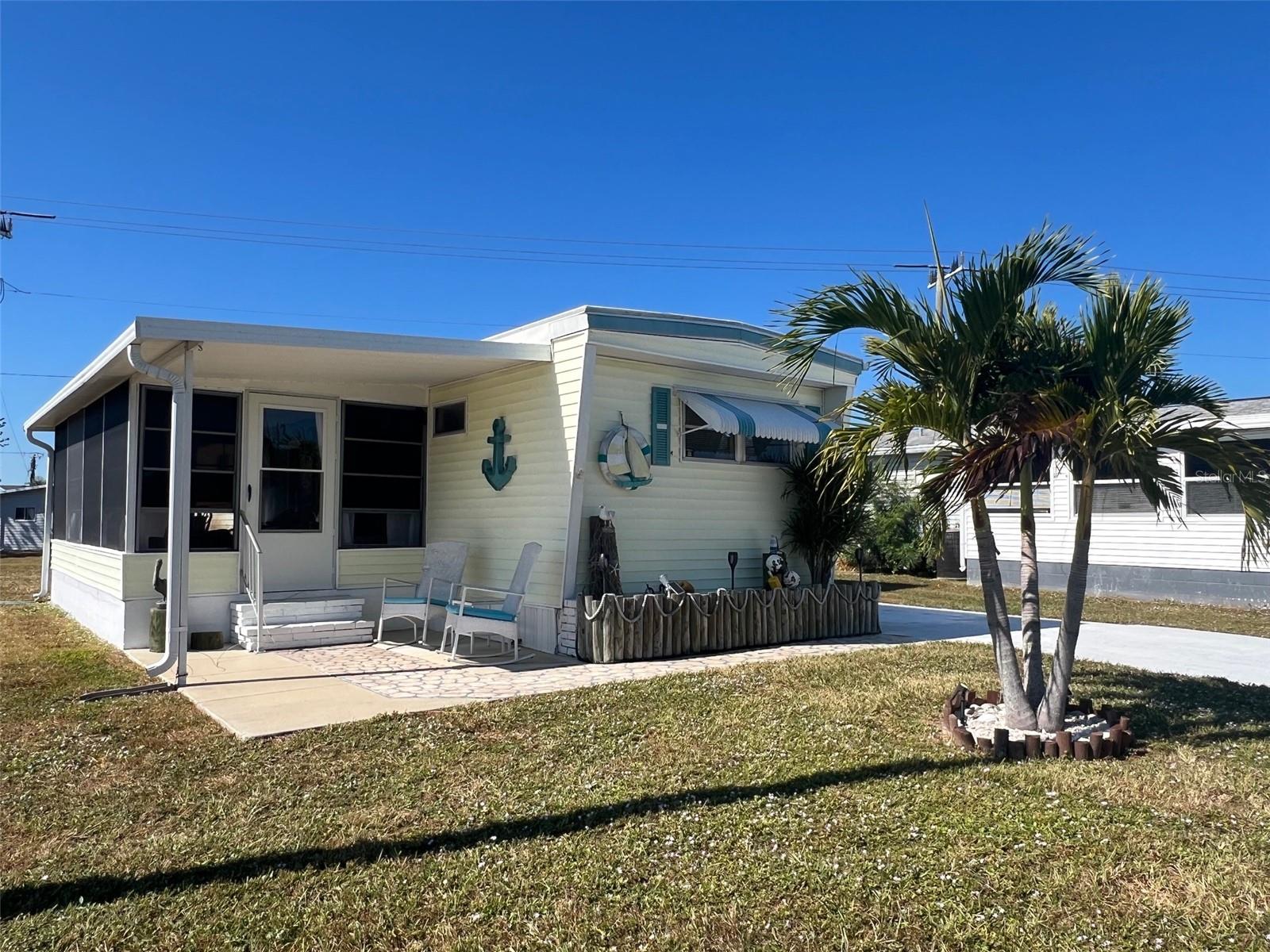 PRICE JUST REDUCED (Again!) — now a FANTASTIC VALUE for coastal-style living in 55+ Harbor Cove! This charming, furnished 2-bedroom, 2-bath home offers the perfect blend of affordability, comfort, and Florida sunshine in one of the area’s most desirable WATERFRONT communities with direct GULF ACCESS via the Myakka River. Thoughtfully updated and beautifully decorated, the home feels instantly welcoming, with an enclosed lanai that adds an additional 200 SQUARE FEET of valuable extra space for casual dining, or relaxing with friends creating a total of 972 SF of indoor/outdoor living. Inside, the home has been refreshed with newer furnishings and a clean, coastal vibe. Important updates within the PAST FIVE YEARS include a roof-over, new carport, electric panel with surge protection, Insta hot water heater, ceiling fans, dryer, and several newer windows. Outside, sit in the rocking chair on the front patio and enjoy your morning coffee or afternoon tea. You’ll appreciate the long driveway when guests stop by and the extra storage plus washer and dryer in the shed. Harbor Cove’s lifestyle is truly unmatched. The two-story clubhouse overlooking the 90-slip marina is the heart of the community, hosting dances, trivia nights, entertainment shows, card games, billiards, picnics, and more. The occasional food truck and vegetable market visits are a treat and very convenient. Residents enjoy two swimming pools, a hot tub, fitness room, tennis and pickleball, bocce, shuffleboard, and even an optional woodworking shop. With boat slips available for only $300 per year, you can cruise miles of scenic waterways and enjoy some truly great fishing along the way. With beaches, golf, restaurants, Costco, retail shops, and quality medical services all nearby, this is the perfect place to enjoy an active, social, and relaxed Florida lifestyle. Come see why Harbor Cove is loved by so many — schedule your private showing today.