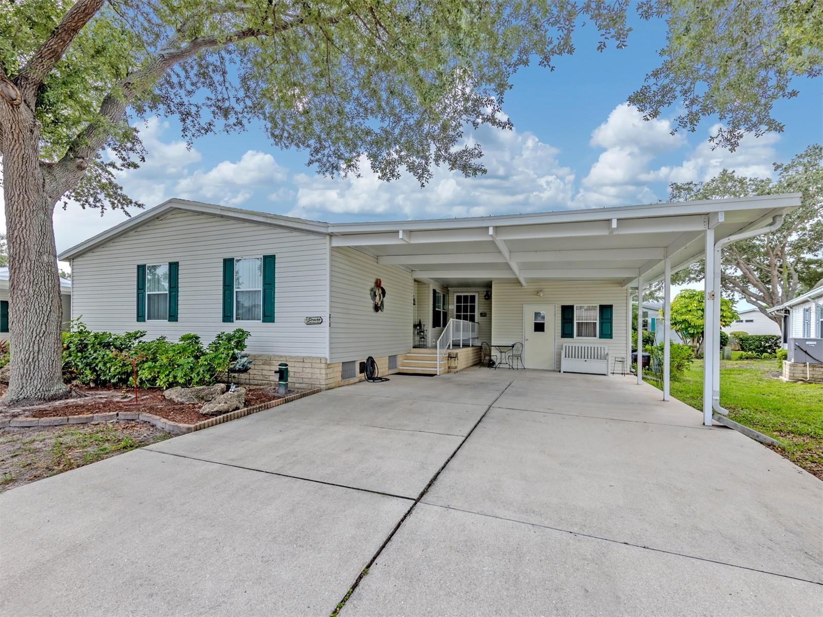 Welcome to easy Florida living in the highly sought-after, pet-friendly community of Riverwalk! This beautifully maintained 2,015-square-foot Palm Harbor triple-wide home, built in 1998, offers the quality craftsmanship Palm Harbor is known for and an incredibly spacious floor plan designed for comfortable everyday living and entertaining.  At the heart of the home is an oversized island kitchen featuring an abundance of cabinetry, generous counter space, and a sunny eat-in dining area. Just off the kitchen, you'll find a large family room that creates the perfect gathering space for family and friends. Step through to the expansive screened lanai, already piped for central air, giving the new owner the option to easily enclose it for additional year-round living space.  The spacious living and dining room combination is filled with natural light and showcases elegant tray ceilings, creating a bright and inviting atmosphere. The home offers three generously sized bedrooms and two full baths, including a large primary suite with a walk-in closet and a beautiful ensuite bathroom.  Additional features include a convenient laundry room just off the kitchen, along with a spacious storage shed that is accessible from the lanai and includes a utility sink, making it perfect for hobbies, gardening, or extra storage.  Major updates provide peace of mind, including a new air conditioning system in 2025, hot water heater in 2024, and a shingle roof installed in 2018.
Riverwalk is one of North Port's most desirable 55+ communities, offering a relaxed, active lifestyle in a beautifully landscaped setting. Residents enjoy a clubhouse, heated pool and spa, fitness center, pickleball and tennis courts, shuffleboard, social activities, walking paths, and a kayak launch with access to Salt Creek and the Myakka River for those who enjoy paddling and the outdoors. Conveniently located near shopping, dining, golf courses, medical facilities, and the Gulf Coast's beautiful beaches, Riverwalk offers the perfect blend of recreation, convenience, and Florida charm.
Don't miss this opportunity to own a spacious, quality-built Palm Harbor home in one of the area's most desirable communities!