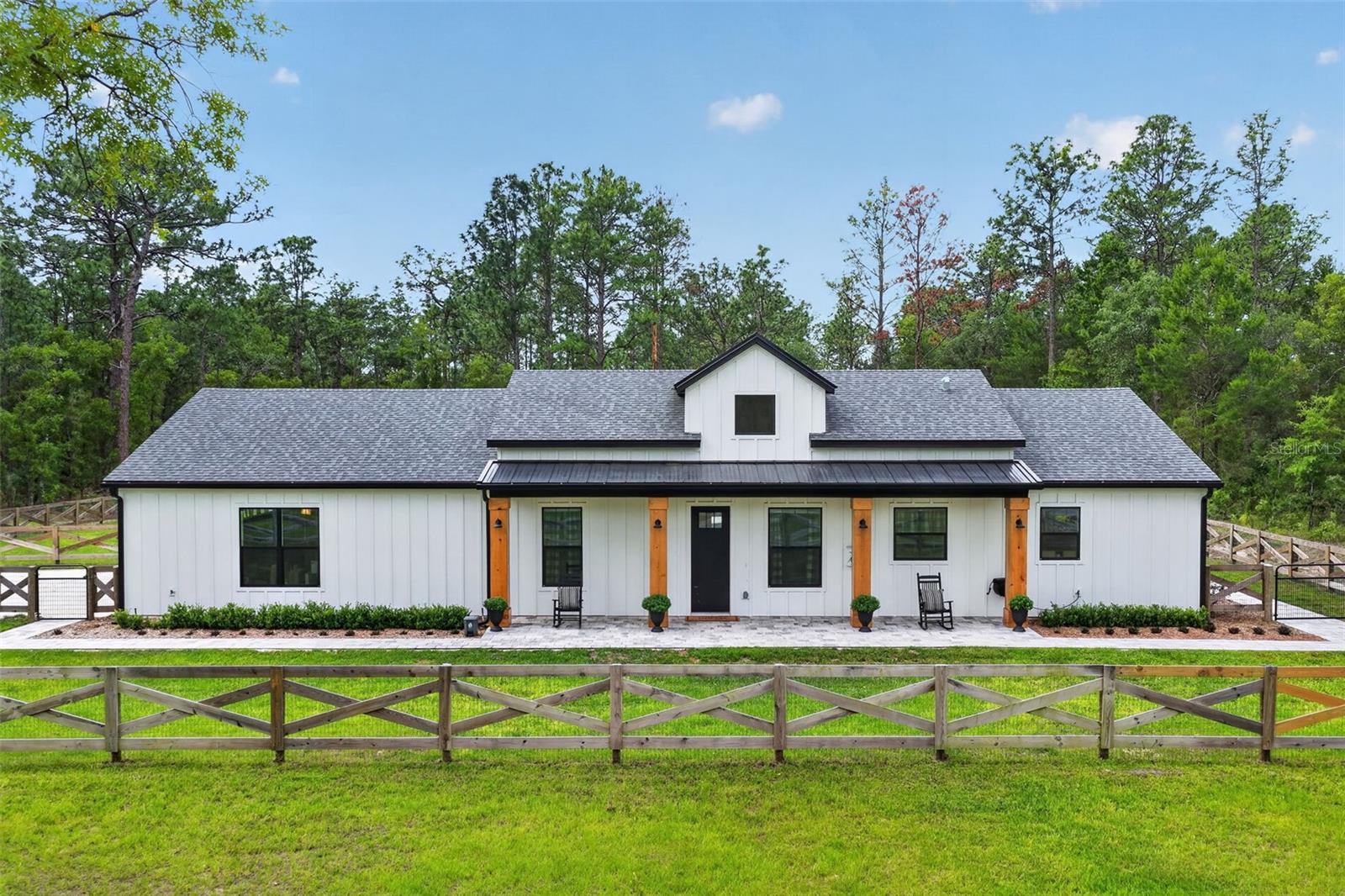 JUST REDUCED, PRICED TO SELL! Farmhouse LUXURY living at its finest in this custom-built 2024 home where thoughtful design meets luxury upgrades throughout with NO HOA! Situated on 1.16 acres, from the moment you arrive, the charming farmhouse exterior, oversized 3-car garage, and inviting curb appeal set the tone for what awaits inside. Step through the front door to an airy open-concept layout featuring soaring ceilings, abundant natural light, luxury vinyl plank flooring throughout, and a desirable split-bedroom floor plan designed for both privacy and functionality. The heart of the home is the beautifully designed kitchen overlooking the spacious living and dining areas, creating the perfect space for entertaining or everyday living. Every detail was carefully selected to blend warmth, comfort, and modern farmhouse character with Quartz countertops, white cabinetry, black stainless appliances, hood to match with pristine woodwork, accent backsplash, built in microwave and oversized island custom finished with stool step and shiplap. The private primary suite offers a relaxing retreat with spa-like on suite and large walk in closet. The additional bedrooms are generously sized and thoughtfully positioned on the opposite side of the home to offer a split floor plan for privacy. If that wasn't enough, step outside and discover your own backyard oasis. Newly completed in 2025, the custom in-ground saltwater pool features a tanning ledge, screen enclosure, heater/chiller system, and expansive patio space (26x44) partially covered by a roof with patio pavers ideal for year-round enjoyment. The fully fenced backyard offers both privacy and plenty of room to relax, entertain, or simply enjoy peaceful Florida evenings. Better than new with upgrades already completed, this move-in ready home combines farmhouse charm with modern convenience and is ideally located near shopping, dining, and major highways for an easy commute while still maintaining a quiet, private feel.