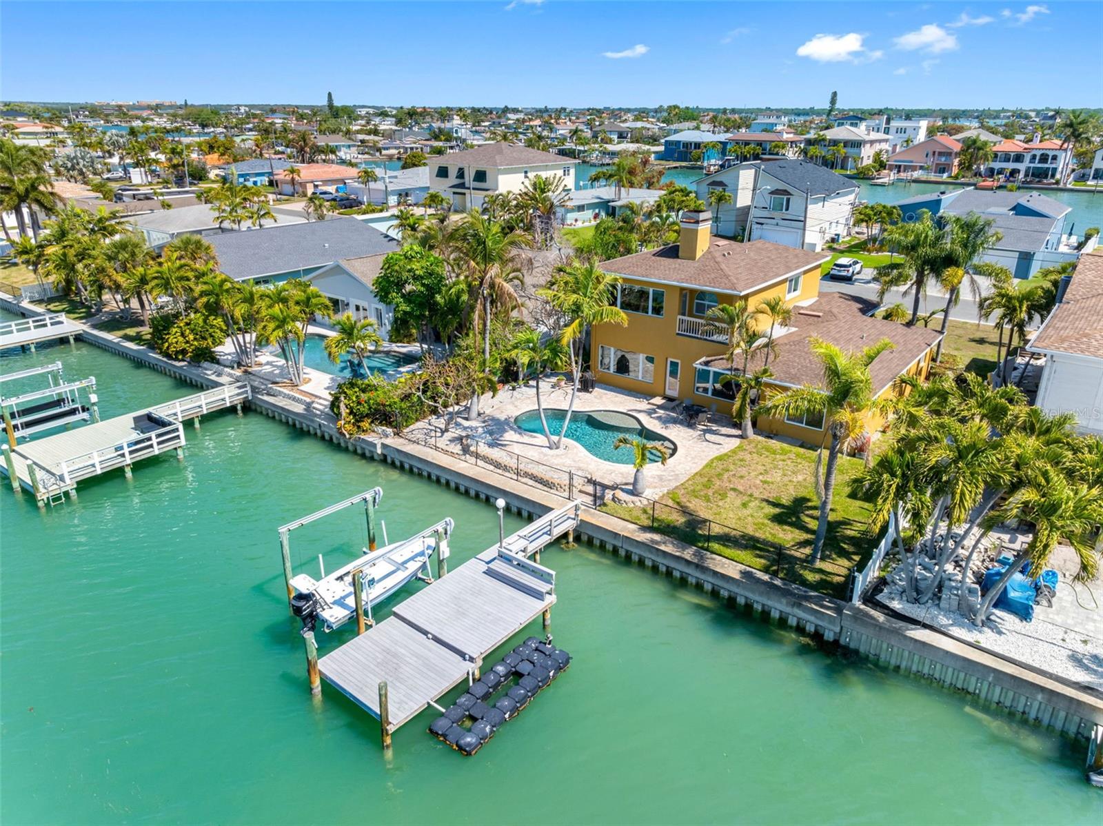 Experience the ultimate in coastal living with this stunning waterfront pool home, perfectly situated on the highly sought-after Isle of Palms in Treasure Island. Boasting over 2,700 square feet of beautifully designed open-concept living space, this residence is tailor-made for both relaxed everyday living and unforgettable entertaining. The heart of the home is a completely updated kitchen featuring all-new cabinetry, stainless steel appliances, and expansive granite countertops—ideal for hosting gatherings with ease. Modern upgrades abound, including new HVAC, water heater, and updated wiring, while Caseta smart lighting allows you to control ambiance both indoors and out with the touch of a button. On the main level, you’ll find two spacious bedrooms, including one with an ensuite bath and serene views of the pool and waterfront. A second full bath, also finished with granite countertops, provides convenience for guests and family alike. Upstairs, the private primary suite offers a true retreat. This expansive space includes a second adjoining room—perfect for a home office, nursery, or additional bedroom—along with an oversized bathroom featuring a two-sided wood-burning fireplace that creates a warm, luxurious atmosphere in both the bedroom and bath. A wet bar, walk-in closet, and private balcony overlooking the PebbleTec pool and tranquil water views complete this exceptional suite.
Step outside to your personal waterfront oasis. The PebbleTec pool sparkles under the Florida sun, while the composite dock with a spacious seating area invites you to unwind with evening “docktails” as you take in breathtaking, technicolor sunsets. Located just moments from Treasure Island’s award-winning beaches, this home places you in the heart of a vibrant coastal community known for its lively festivals, including the world-renowned sand sculpting competition. Enjoy charming local shops, waterfront dining, and fresh-caught seafood delivered straight from the boats. This is more than a home—it’s a lifestyle.