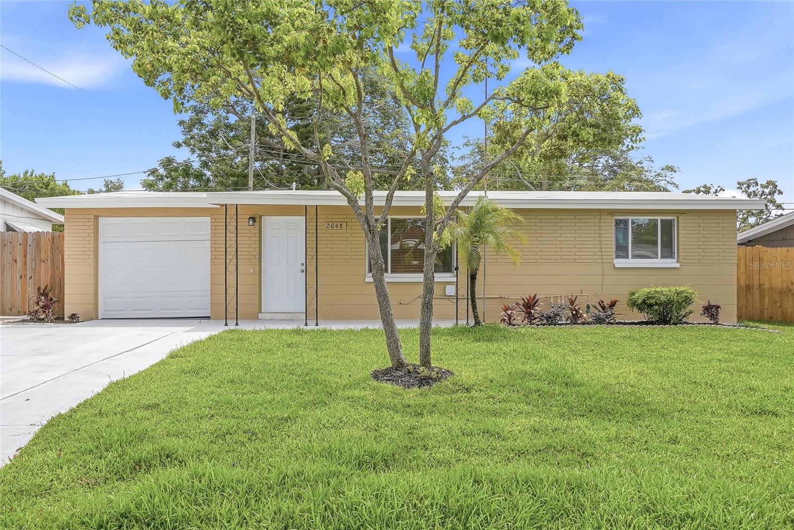 Welcome to this updated 2-bedroom, 1-bathroom block home offering fresh finishes, comfortable living spaces, and a backyard made for enjoying the Florida sunshine. From the covered front porch and freshly laid sod to the inviting interior, this home is move-in ready and waiting for its next owner. Inside, luxury vinyl plank flooring flows throughout the home, creating a clean and cohesive feel. The kitchen has been completely refreshed with new cabinetry, warm butcher block countertops, and a full suite of brand-new appliances, providing a functional and welcoming space for everyday living. Just beyond the main living area, the screened and covered Florida room offers additional space to relax, entertain, or enjoy the outdoors in comfort year-round. The fully fenced backyard features a sparkling fiberglass pool with clear, well-maintained water, plus an irrigation system and gutters for added convenience. A one-car garage with a washer and dryer completes the home's practical layout. Conveniently located in Holiday, you'll enjoy easy access to US-19, local parks, shopping, dining, and the waterfront attractions of nearby Tarpon Springs. Whether you're searching for a full-time residence, seasonal retreat, or investment opportunity, this well-maintained home offers a wonderful combination of updates, outdoor living, and everyday comfort.